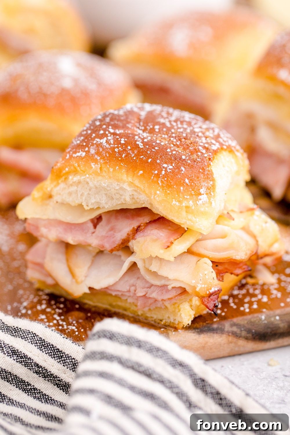 A baking tray filled with perfectly assembled sandwich sliders, ready to be basted and baked.