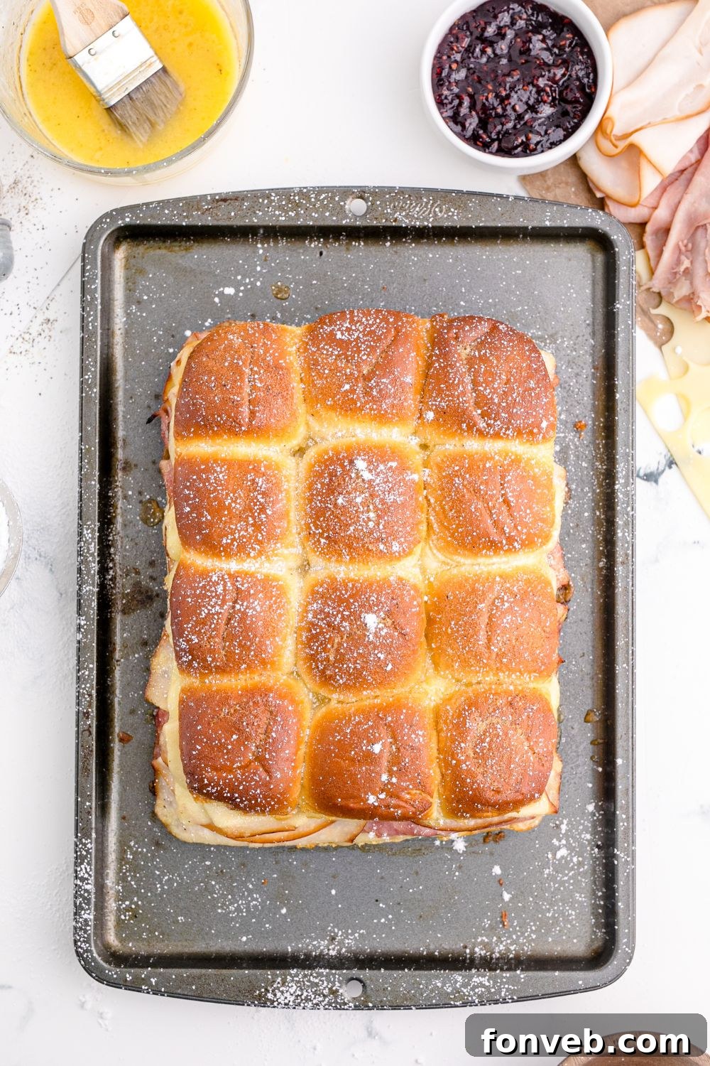 Golden-brown sliders arranged on a cooking tray, fresh from the oven.