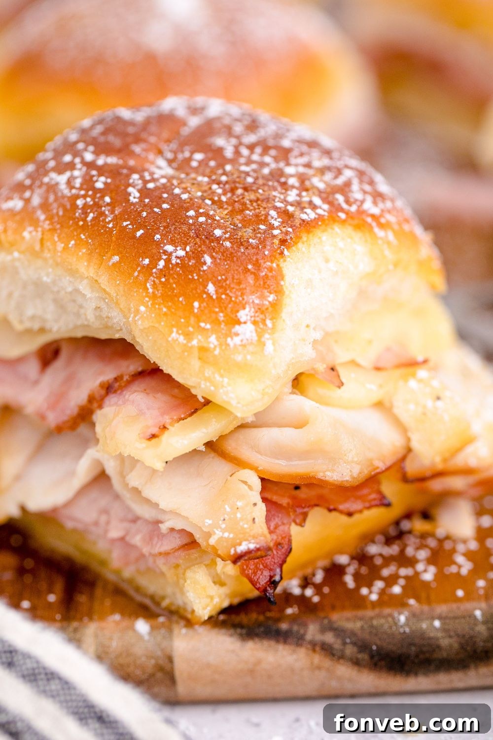 A side view of a Monte Cristo Slider showcasing its layered ingredients on a tray.
