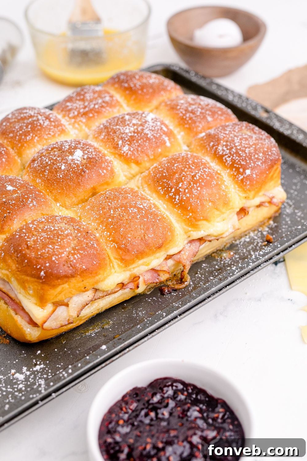 Rows of Monte Cristo Sliders fresh out of the oven on a baking sheet.