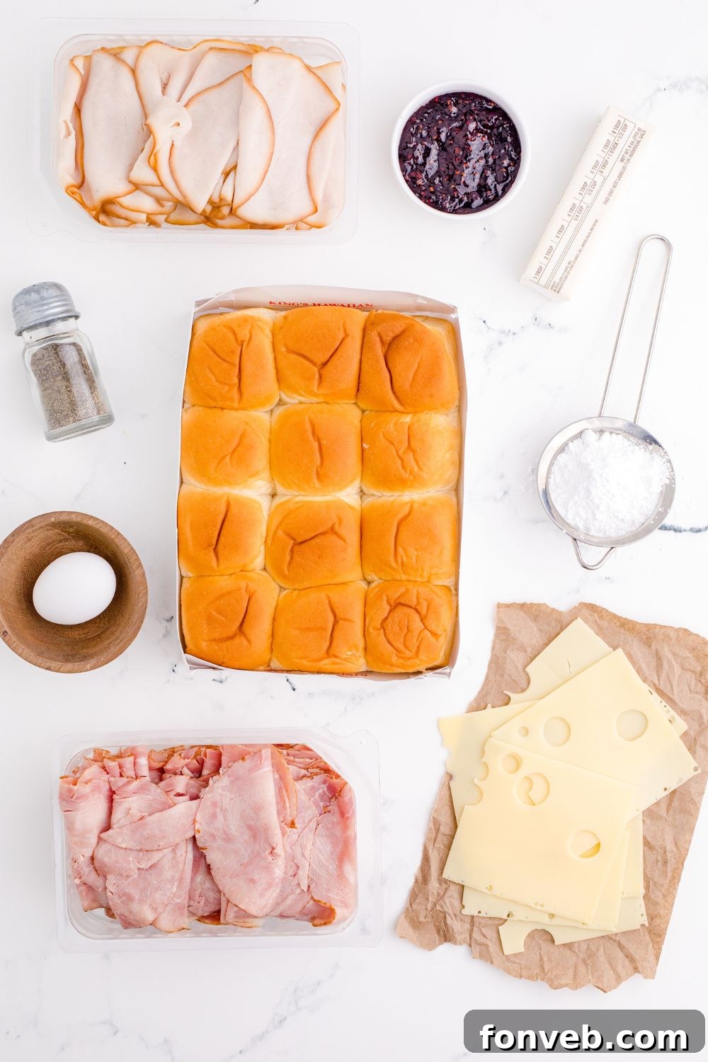 All the fresh ingredients for Monte Cristo Sliders laid out on a wooden table, ready for assembly.