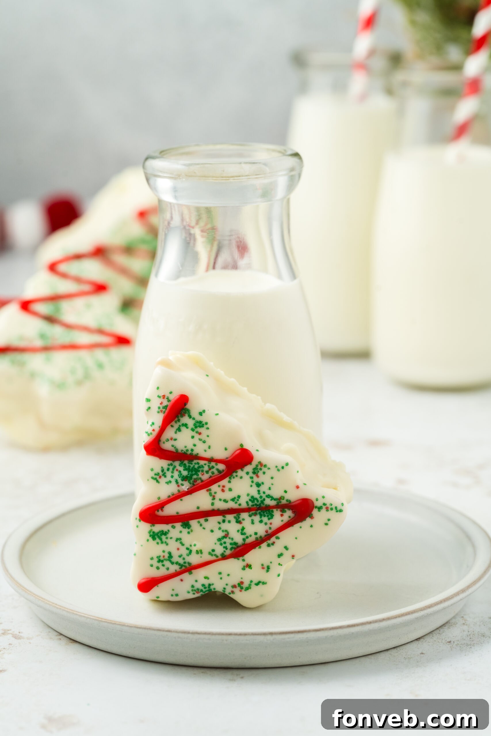 Christmas Tree Snack Cakes from Scratch 3 A single copycat Little Debbie Christmas Tree Cake on a plate with a glass of milk in the background