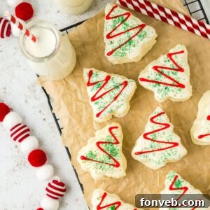 Christmas tree cakes on a table with milk and Christmas decorations around it