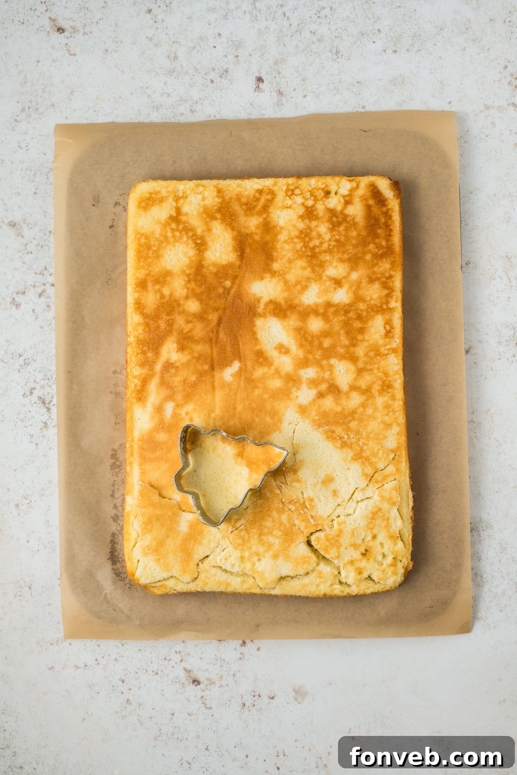 Christmas Tree Snack Cakes from Scratch 10 A Christmas tree cookie cutter being used to cut shapes from a 9x13 cake