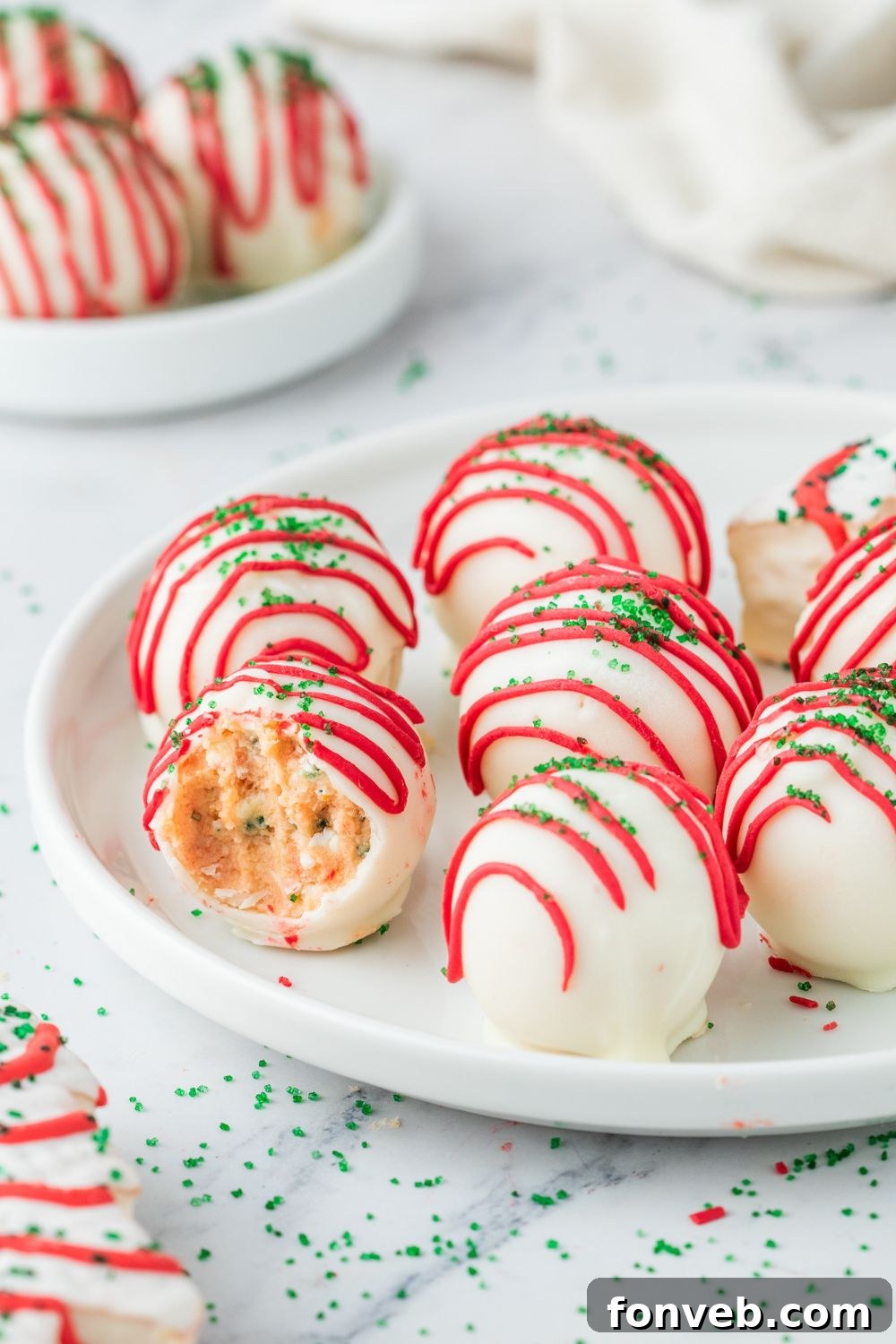 cake truffles on a plate with one that has a bite taken out of it