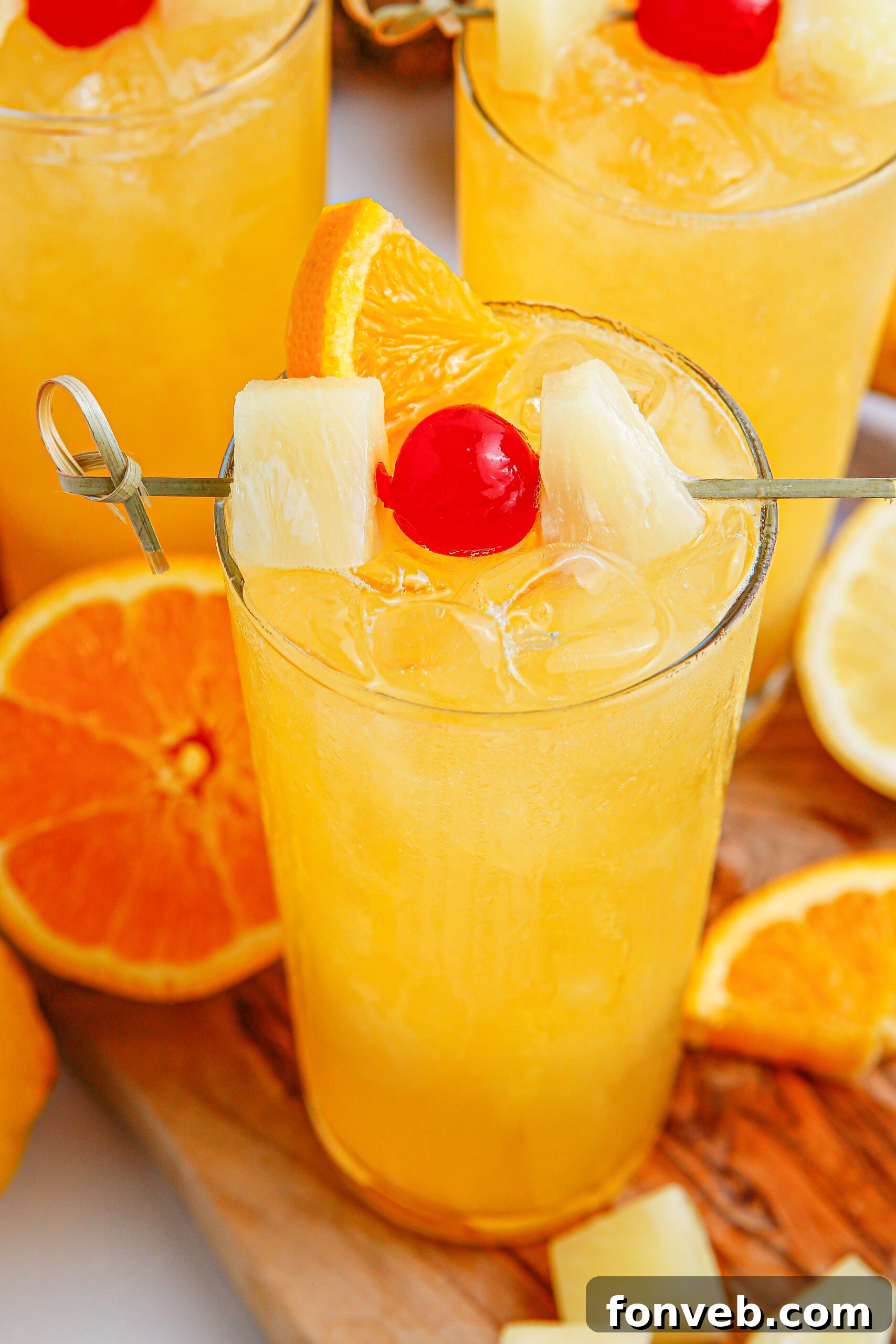 glass of punch on table with orange and cherry on top 