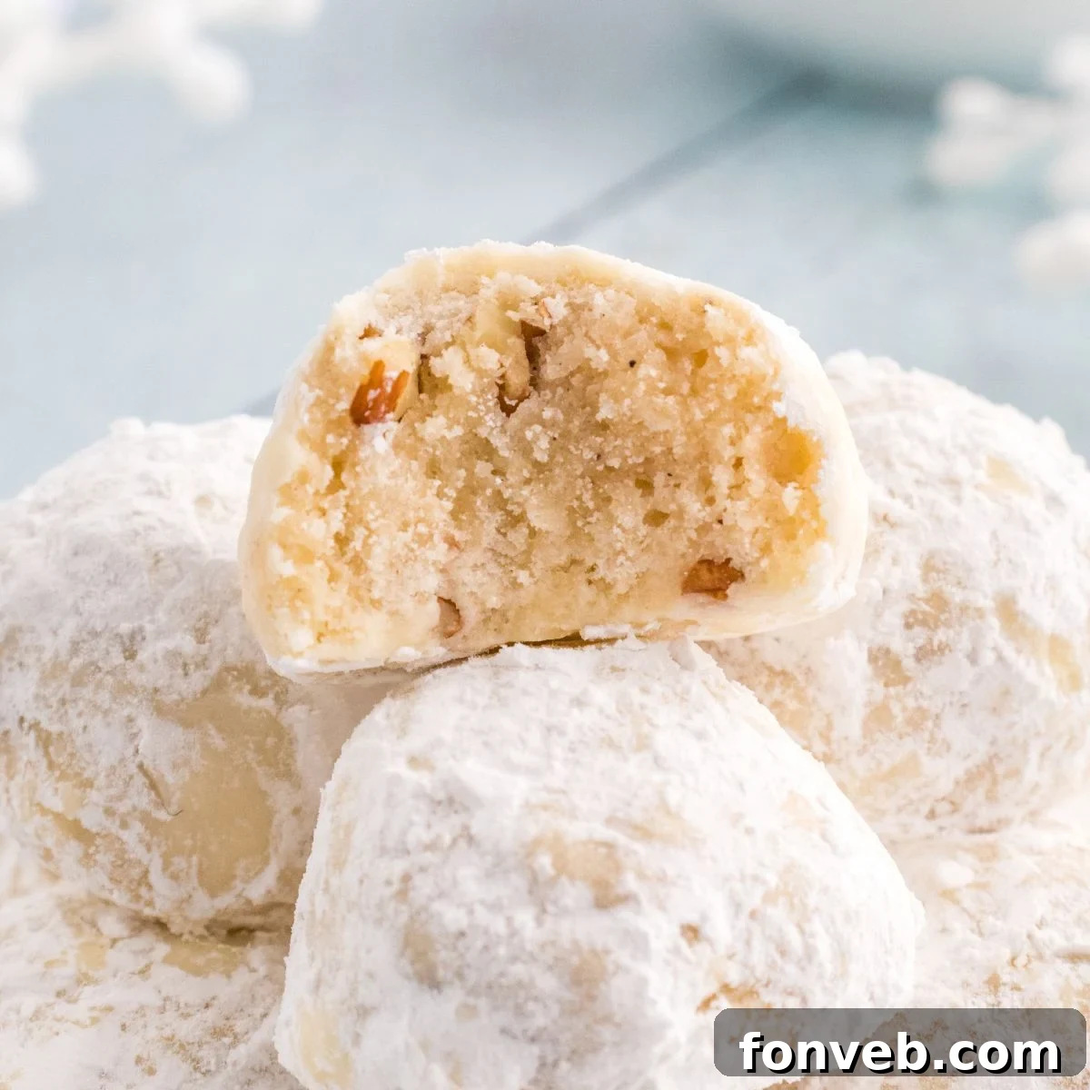 Snowball Cookies on table with one that has a bite taken out of it