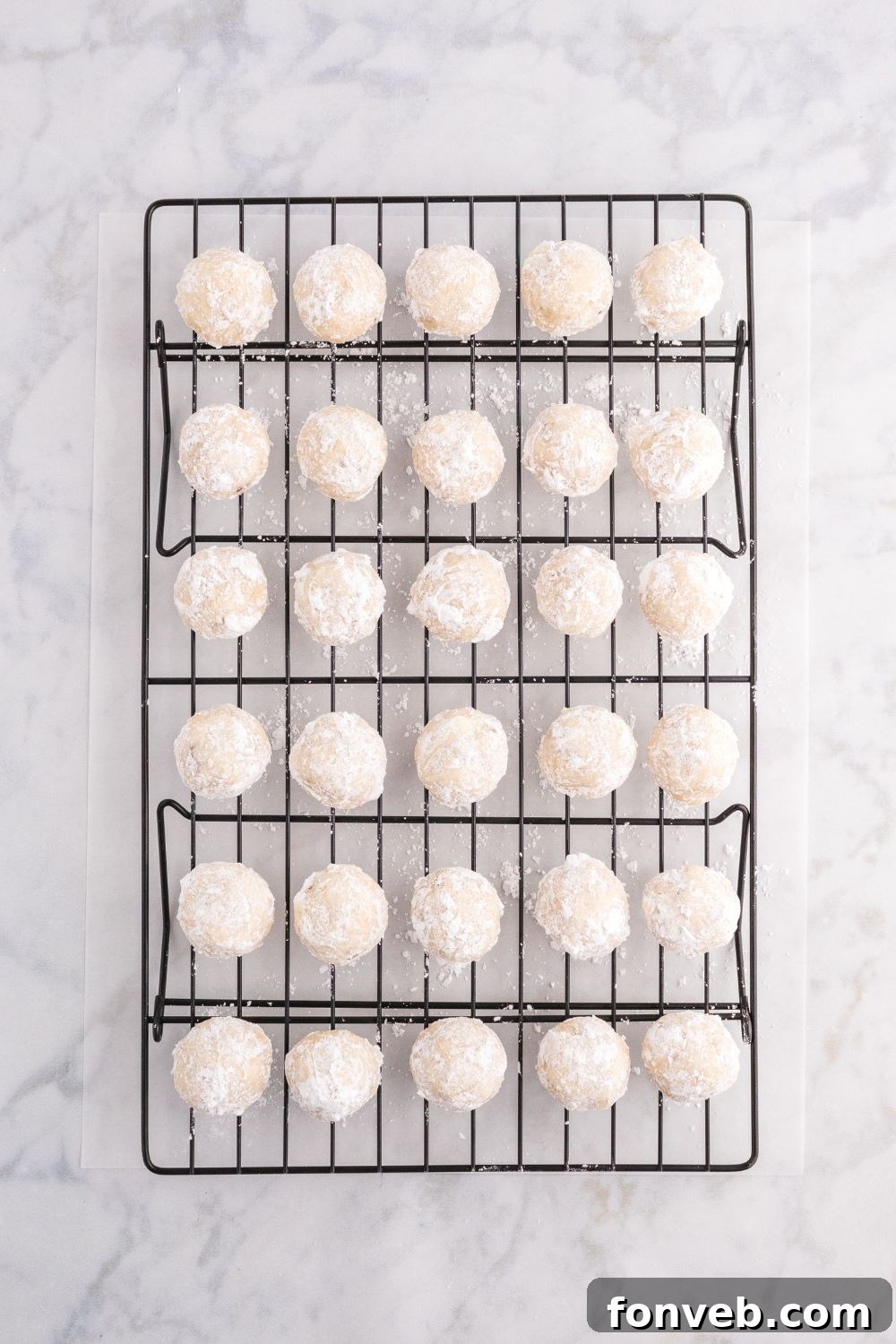snowball cookies placed on a cooling rack on table 