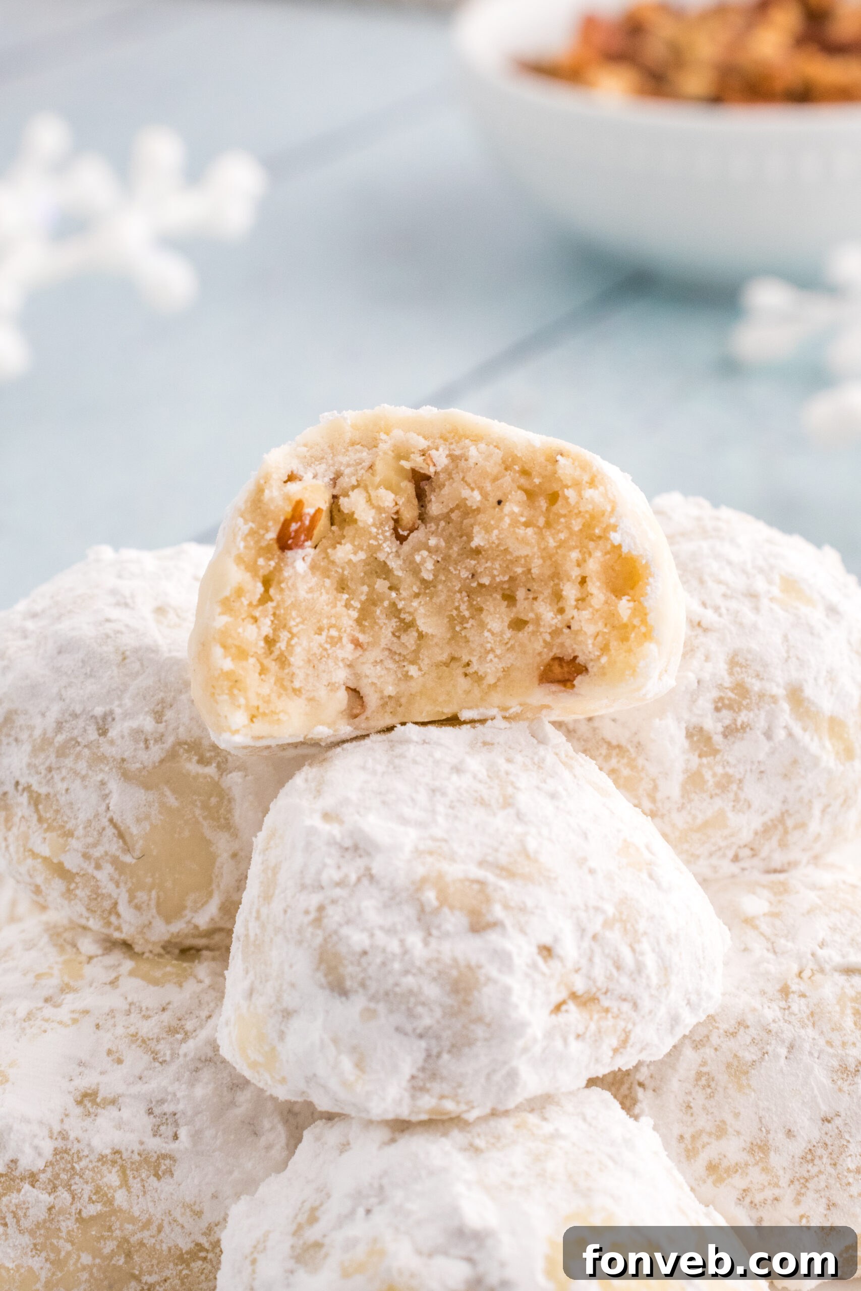 Snowball Cookies on table with one that has a bite taken out of it