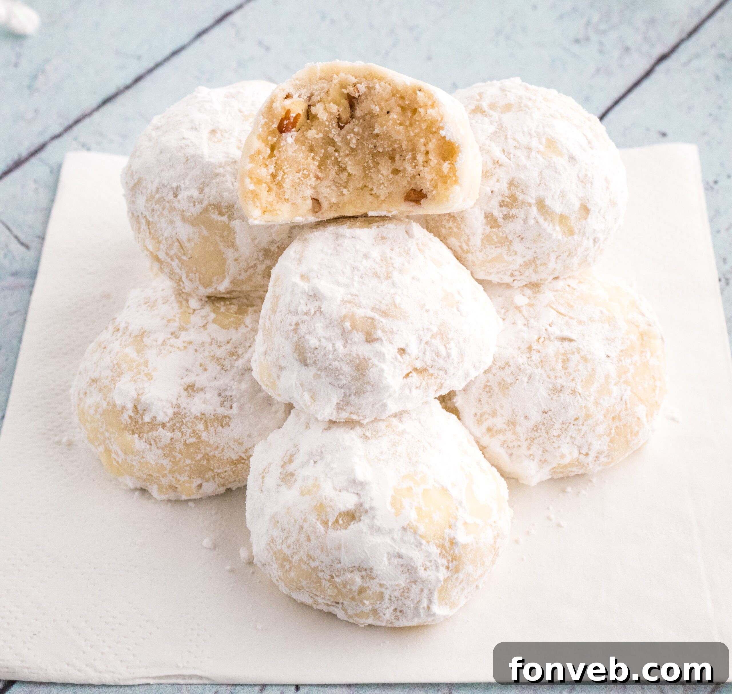 Snowball Cookies on table with one that has a bite taken out of it