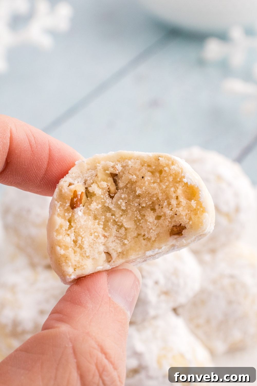christmas snowball cookie in hand with bite taken out of it