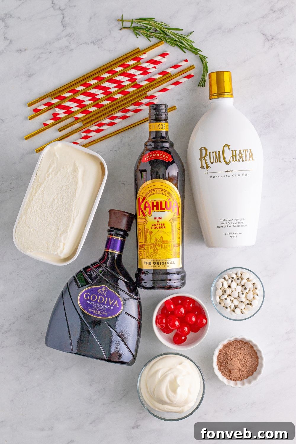 Ingredients for a boozy holiday milkshake, including ice cream, liquors, and garnishes, laid out on a table.