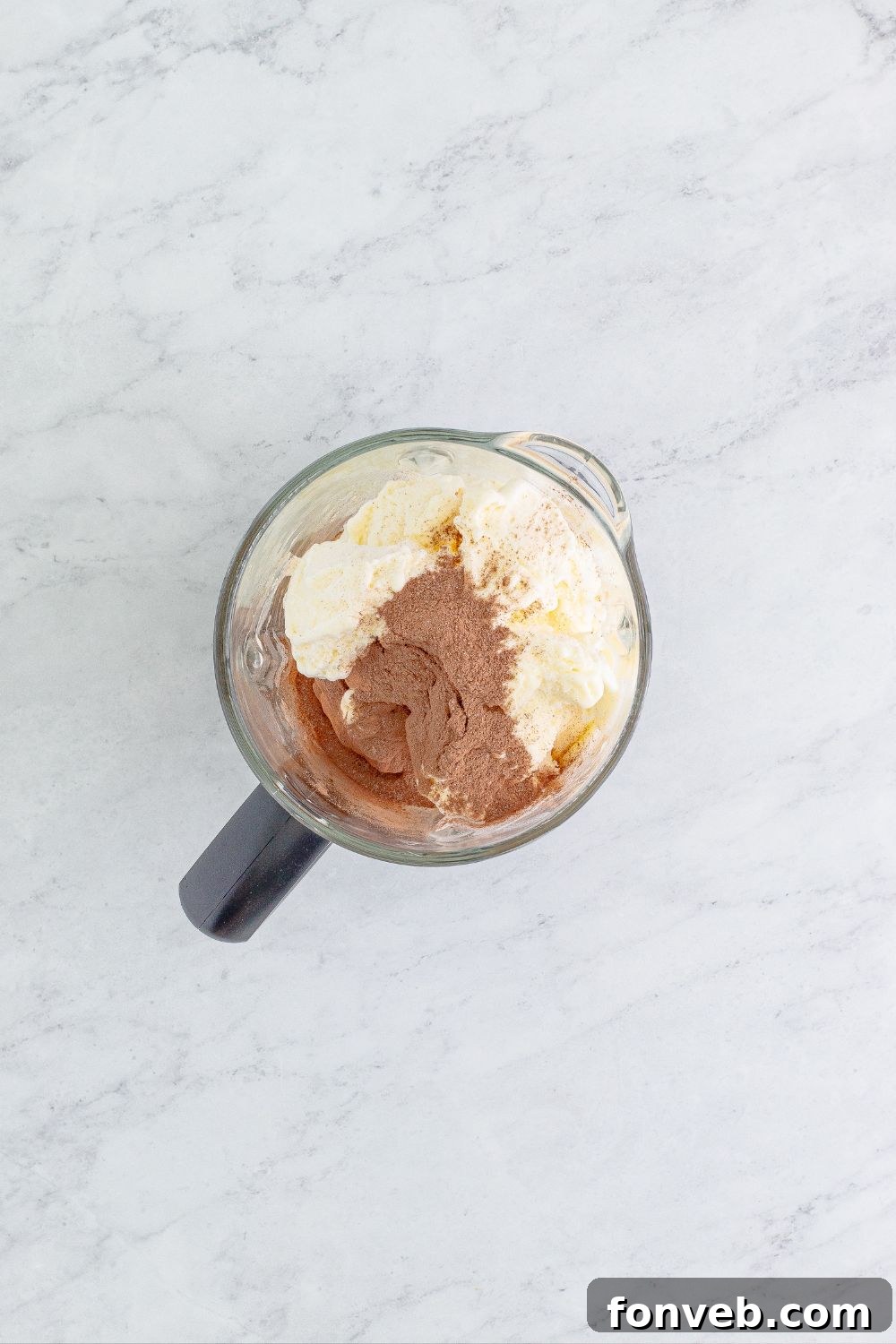 Cocoa mix and ice cream swirling in a blender, creating the base for the rich milkshake.