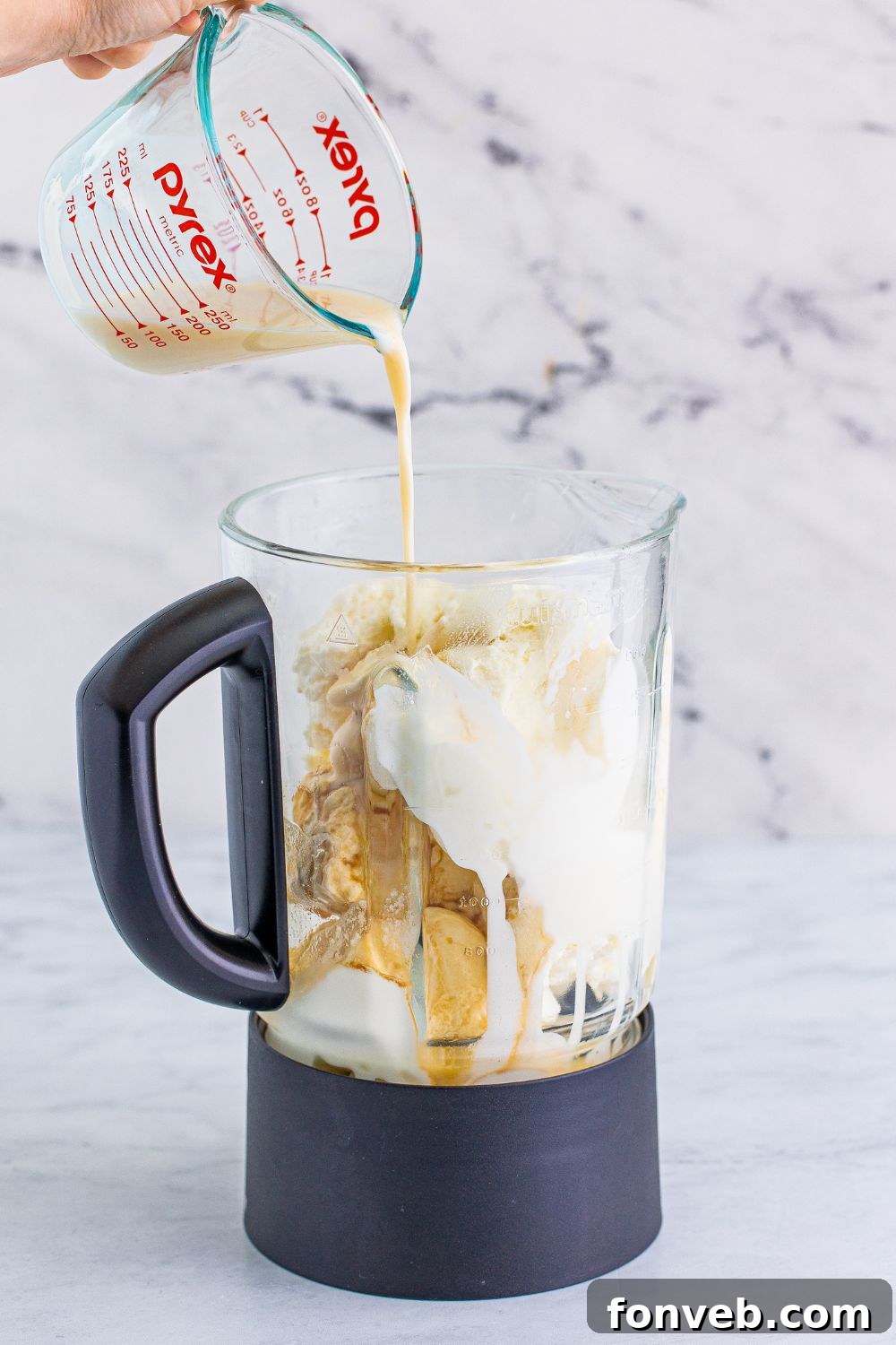 Kahlua liquor being poured into the blender, contributing to the coffee-infused flavor of the adult milkshake.