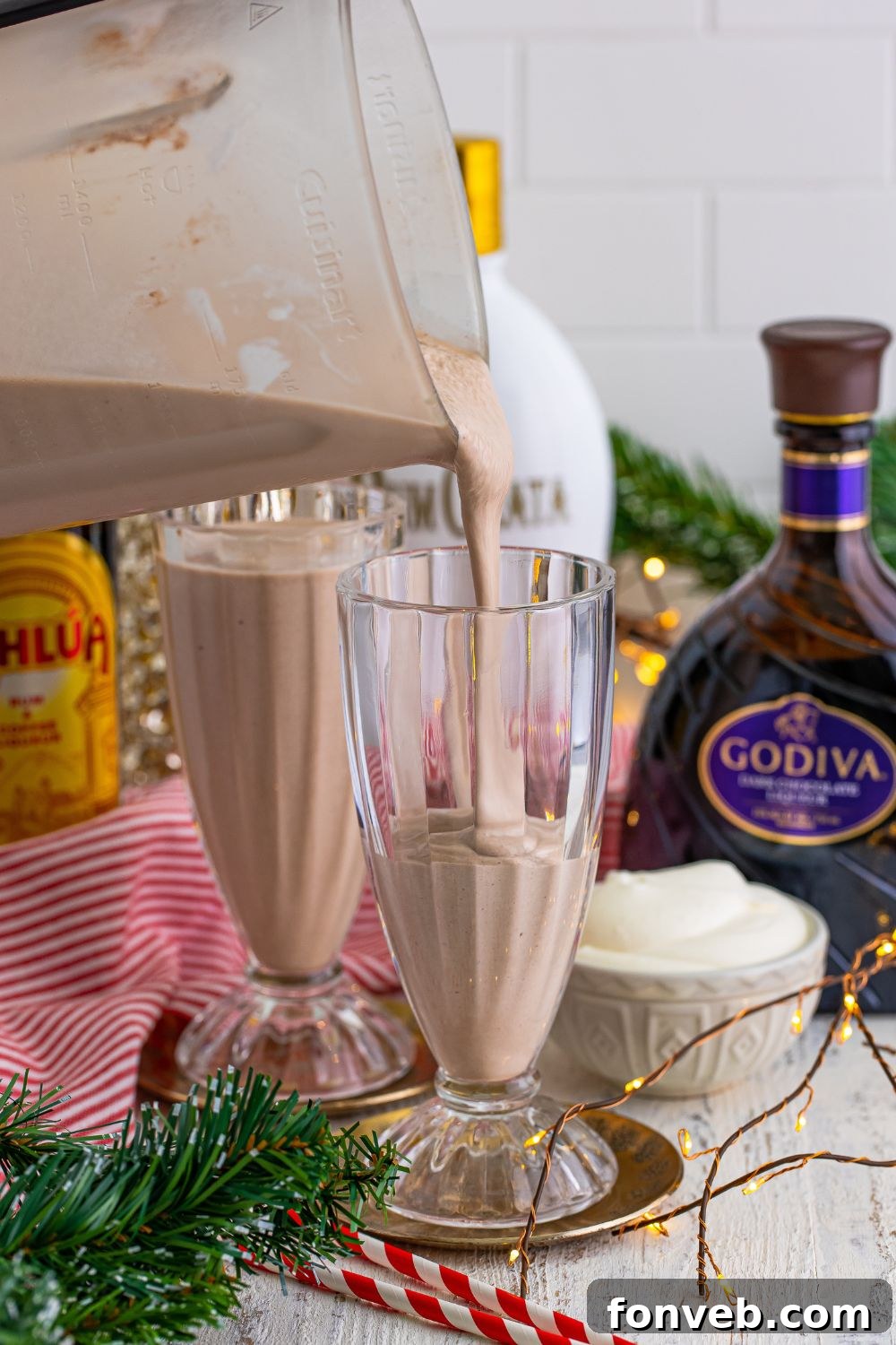 Pouring the freshly blended Drunk Rudolph Milkshakes into festive serving glasses.
