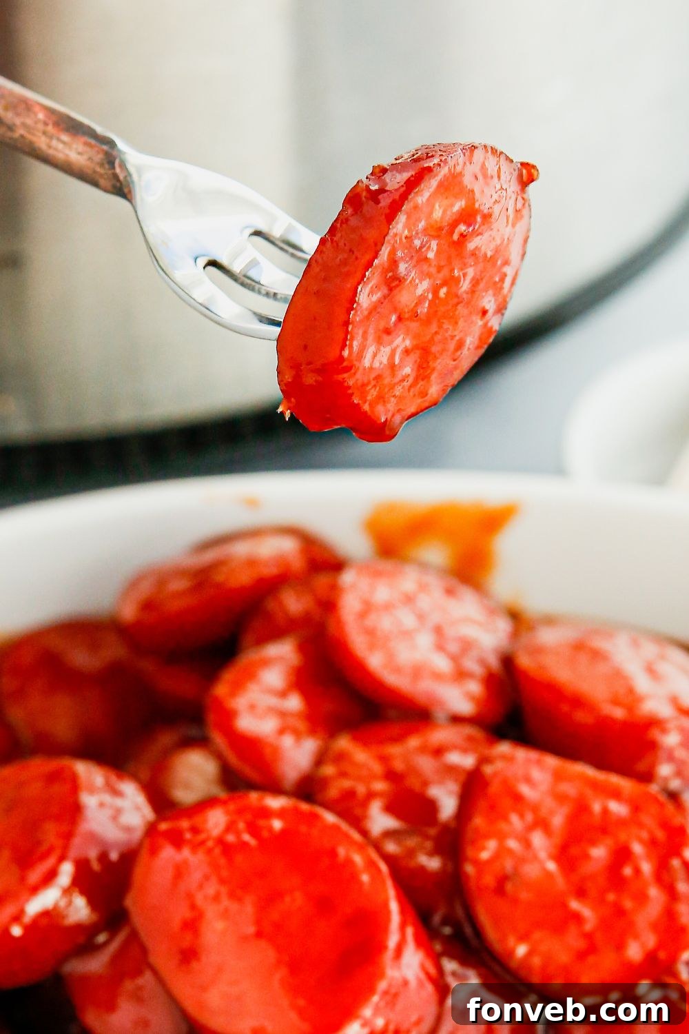 A large bowl filled to the brim with delicious, saucy kielbasa bites.
