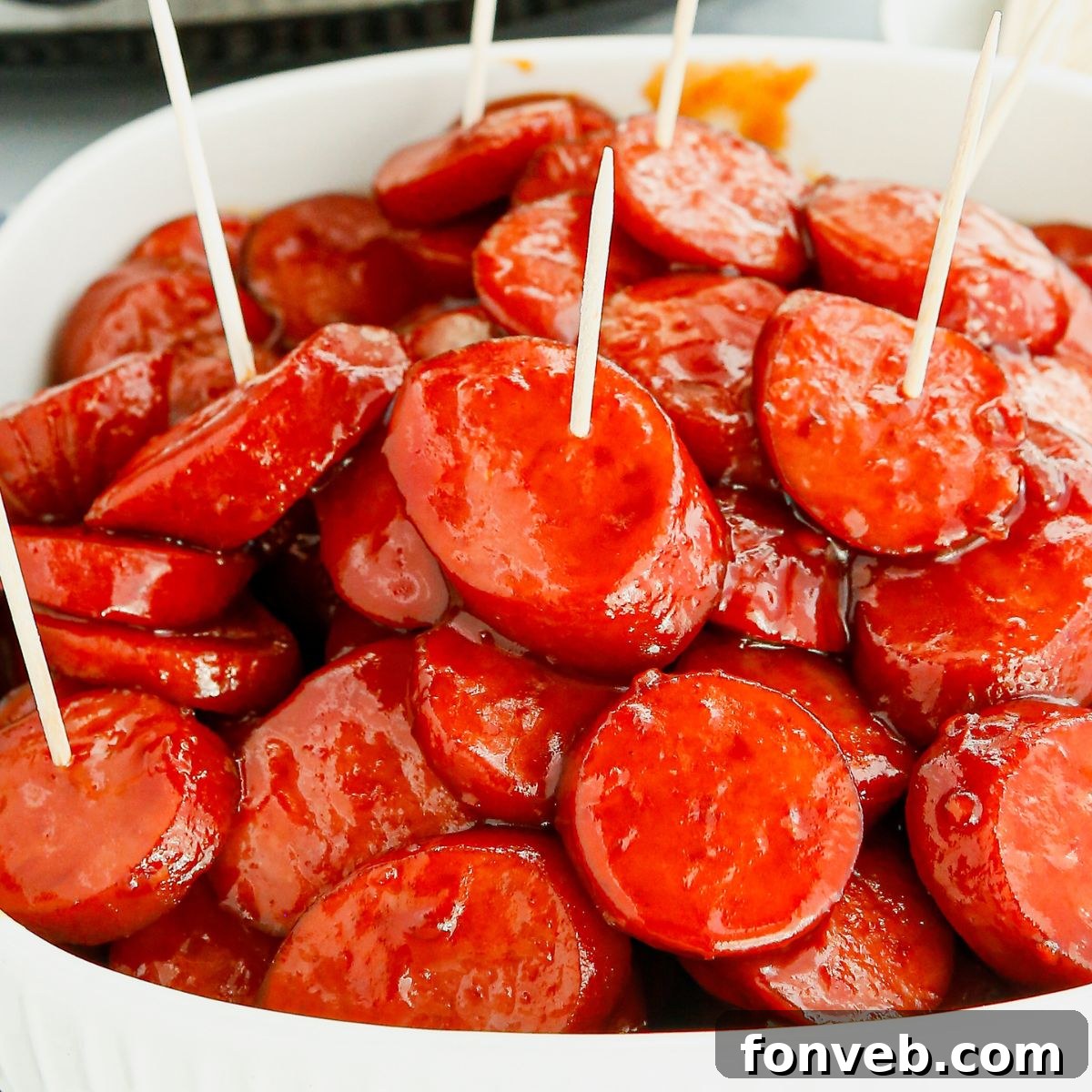 Sweet and savory Crockpot Kielbasa Bites in a serving dish on a wooden table, ready for a party.
