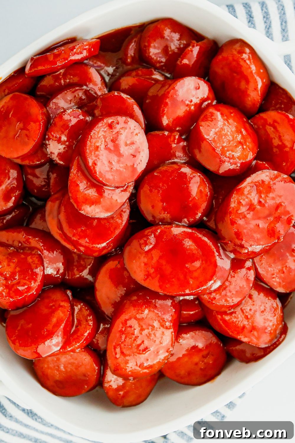 A plate of perfectly glazed kielbasa bites, garnished and ready to be enjoyed.