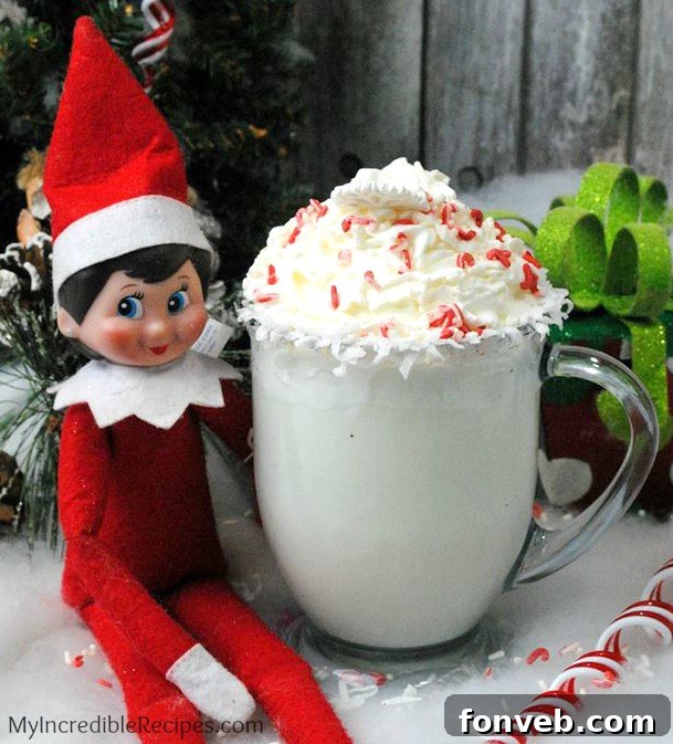 Two mugs of white hot chocolate; one garnished with crushed candy canes, the other with a whole candy cane