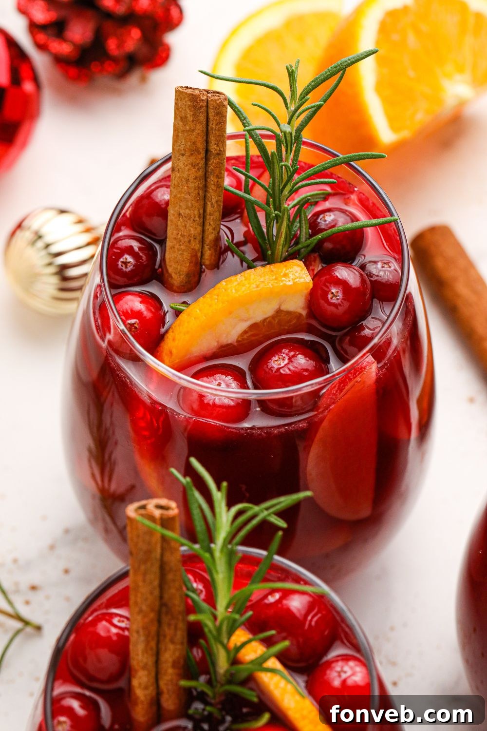 Two glasses of sangria with fruit garnishes on a table, ready for serving.