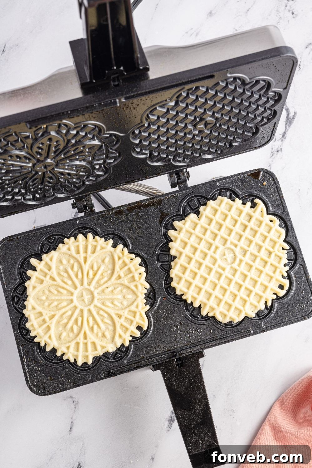Pizzelles in iron on table 
