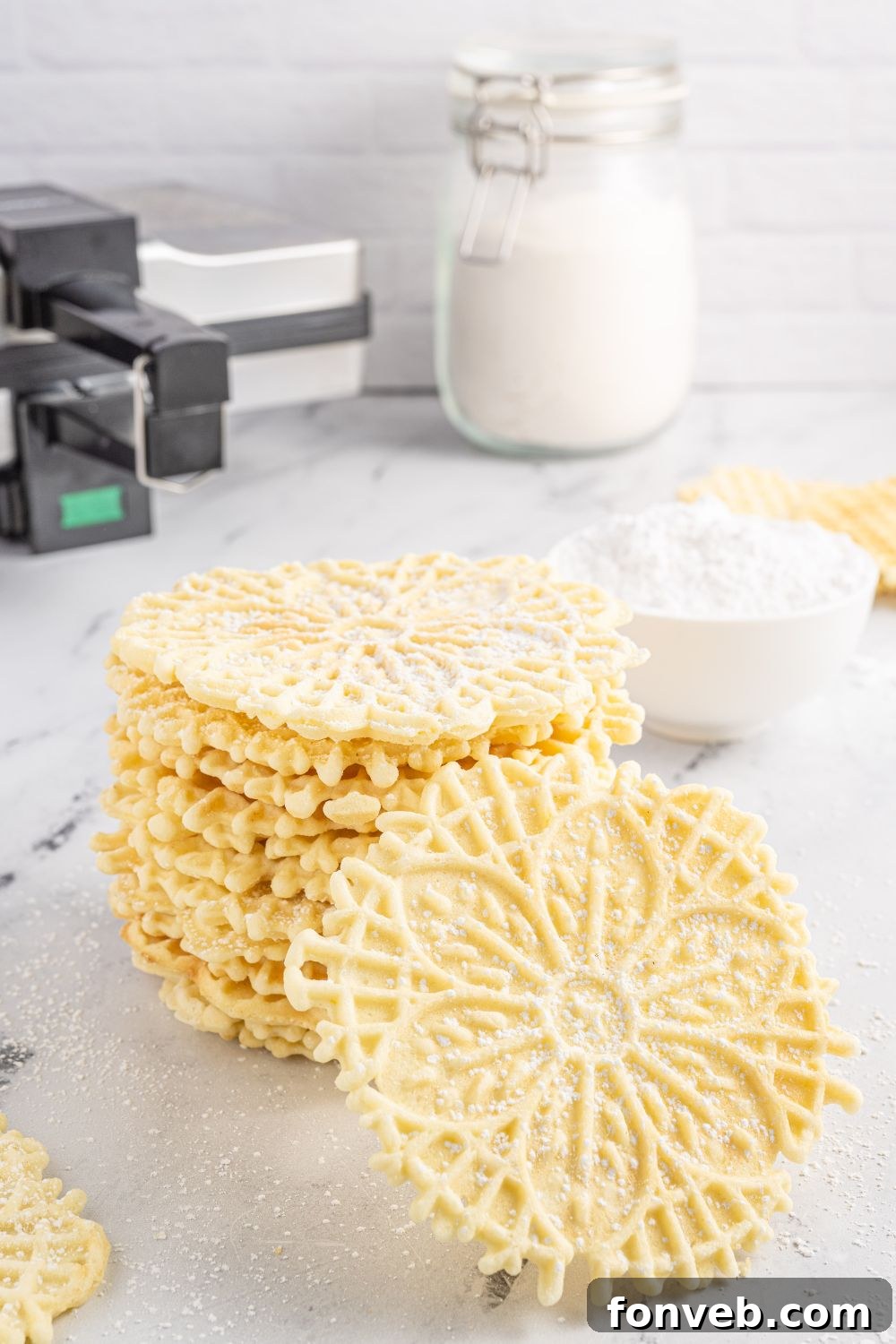 Pizzelles on tray with ingredients behind it 