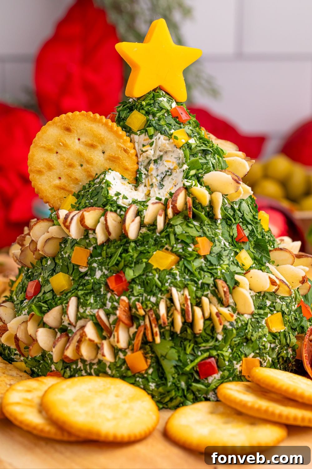 Christmas tree cheeseball appetizer on a decorated table, surrounded by serving options