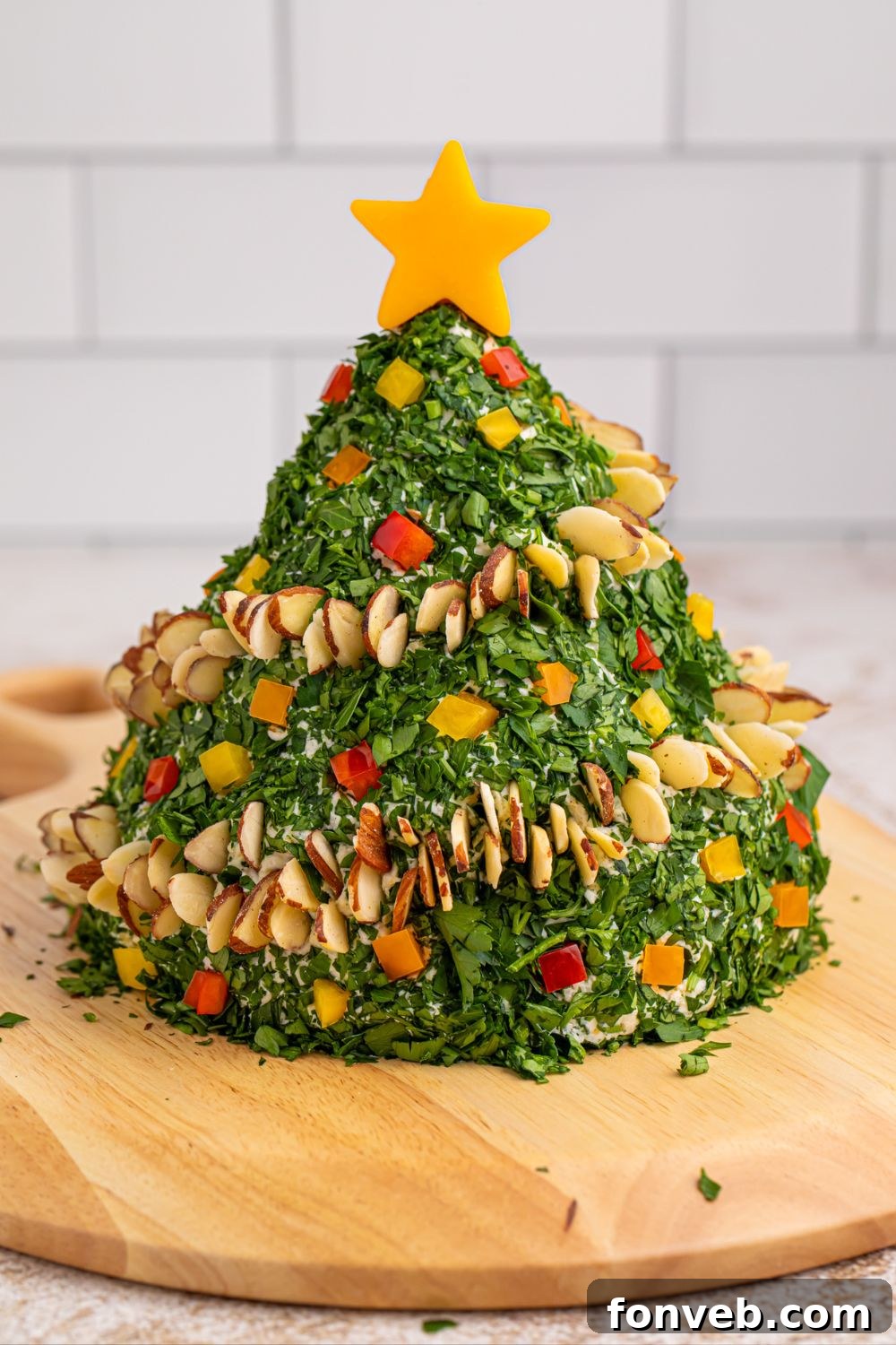 Christmas Tree Cheeseball displayed on a rustic wooden cutting board