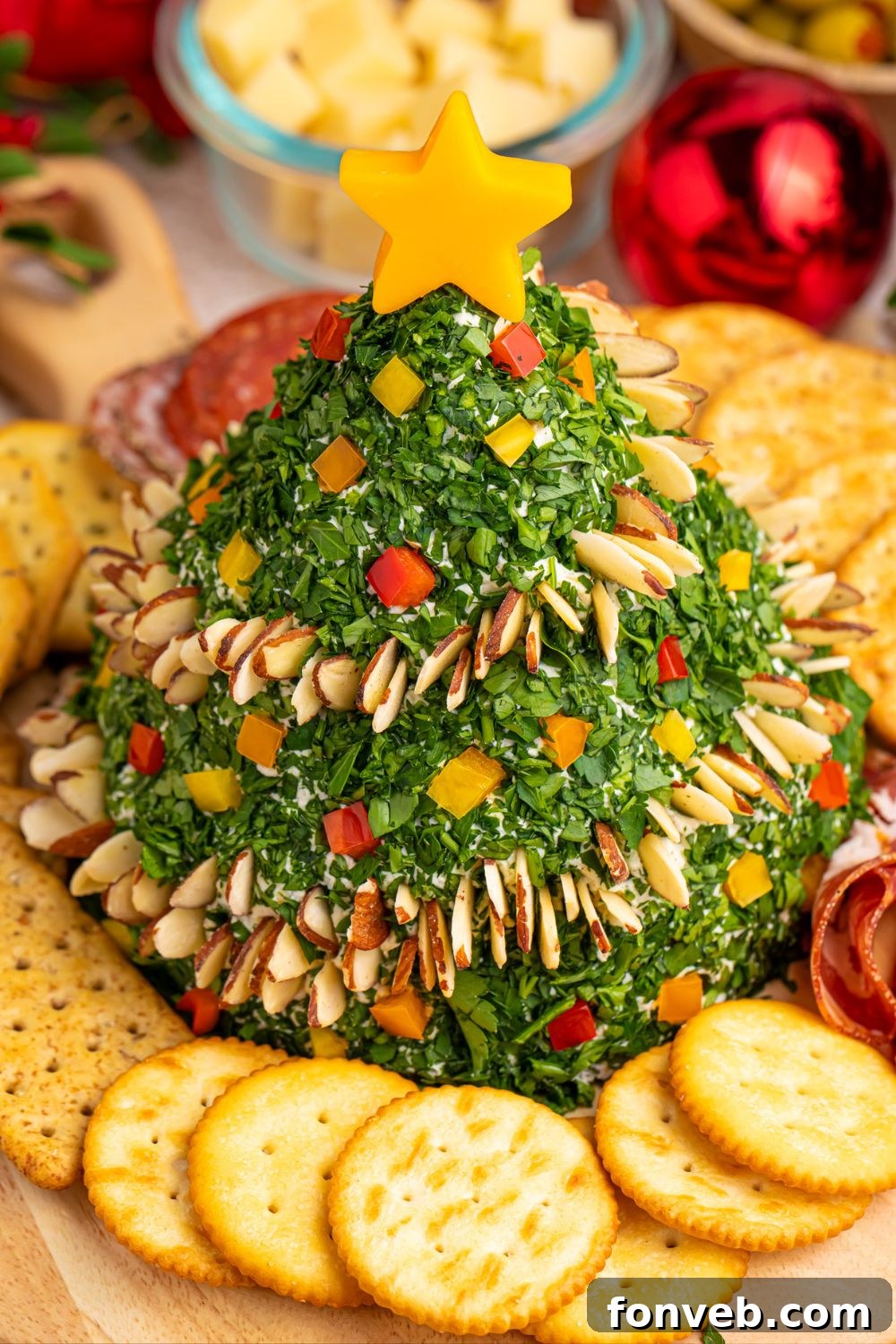 Christmas tree dip on platter with crackers and fresh vegetables surrounding it