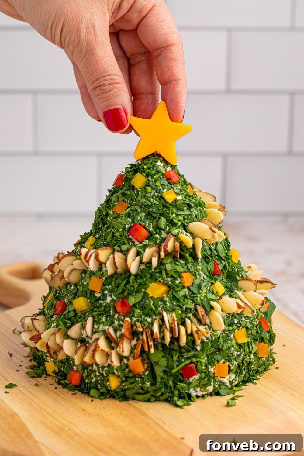Decorated cheeseball with a cheese star on top, ready for serving on a wooden table