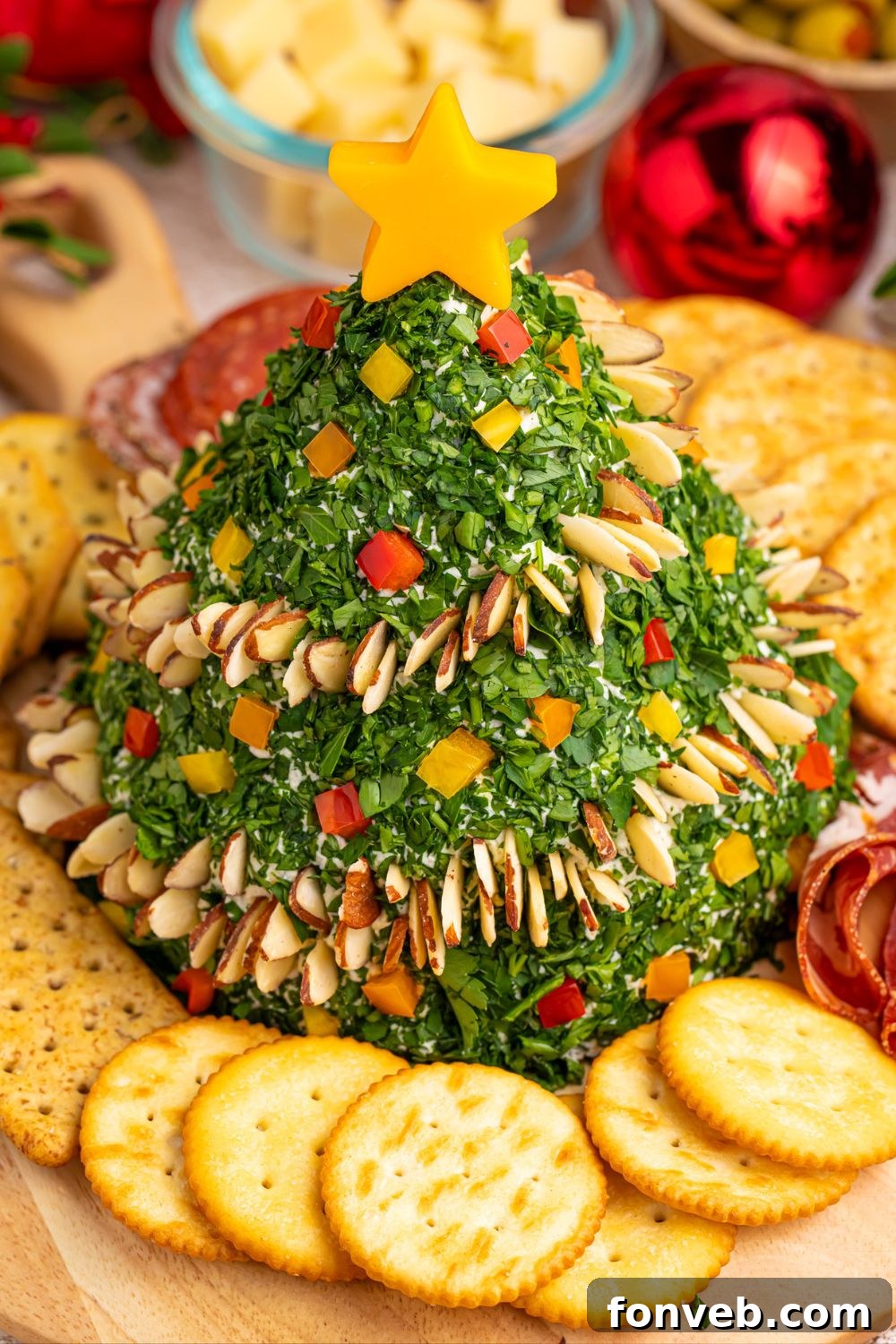 Side view of the decorated cheeseball with an assortment of crackers and snacks around the platter