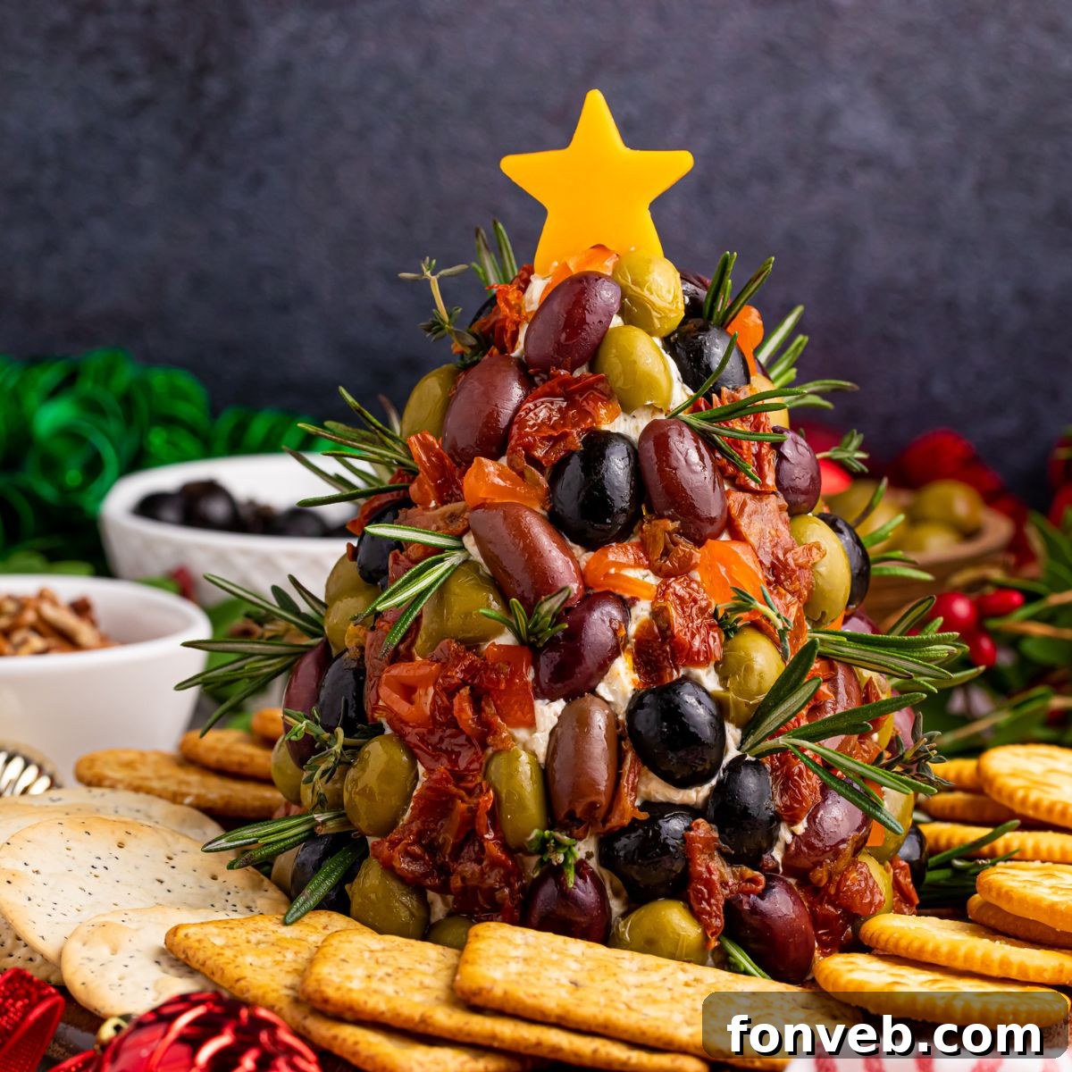 Antipasto Christmas Tree cheeseball on table with crackers around it, ready to serve