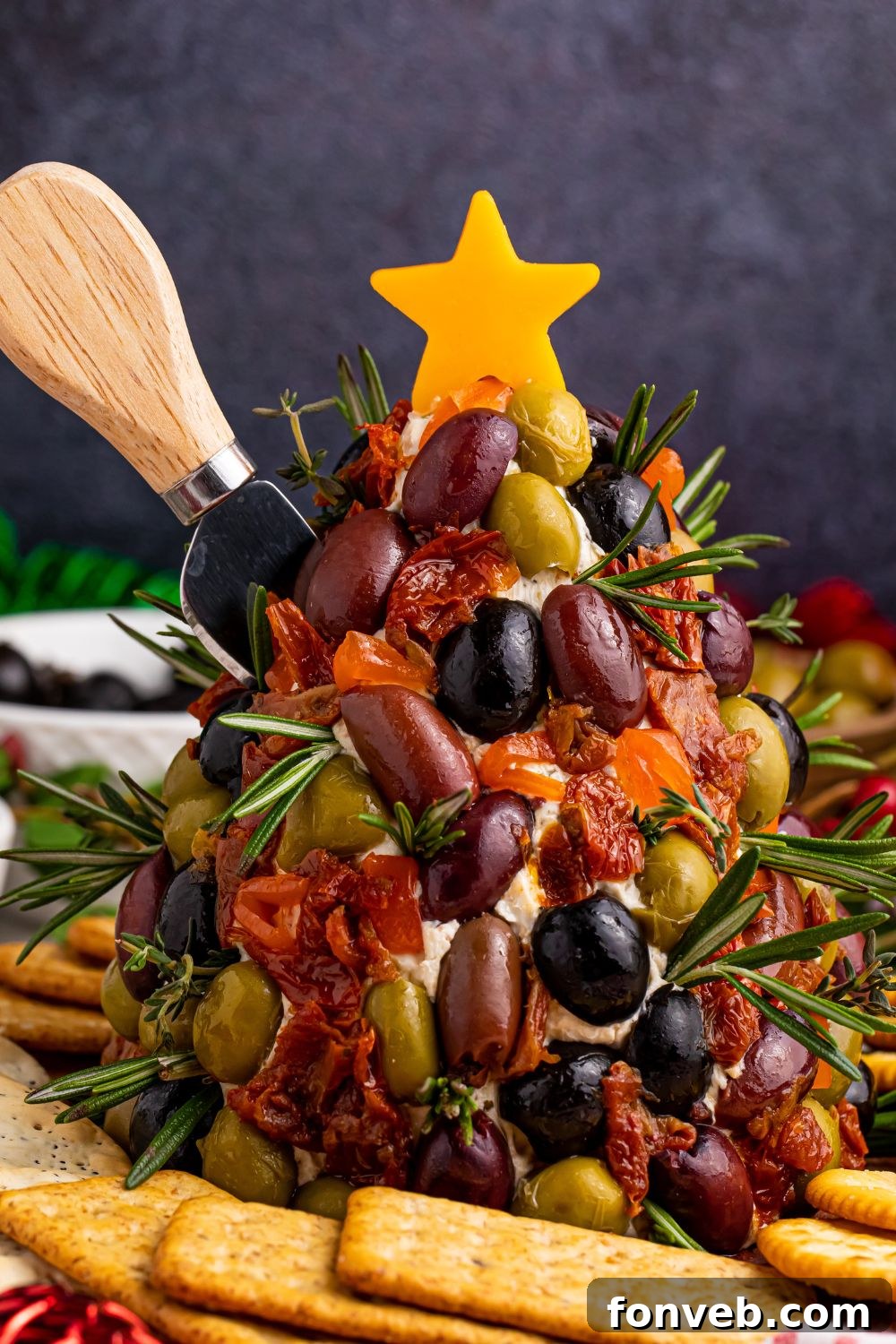 Antipasto cheeseball with a knife stuck in it on the side, ready for serving