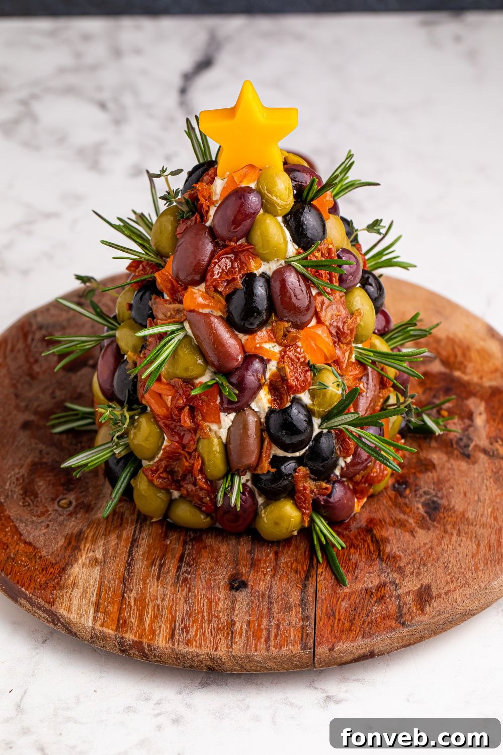 Overhead look of cheeseball on a round cutting board on table, before decoration