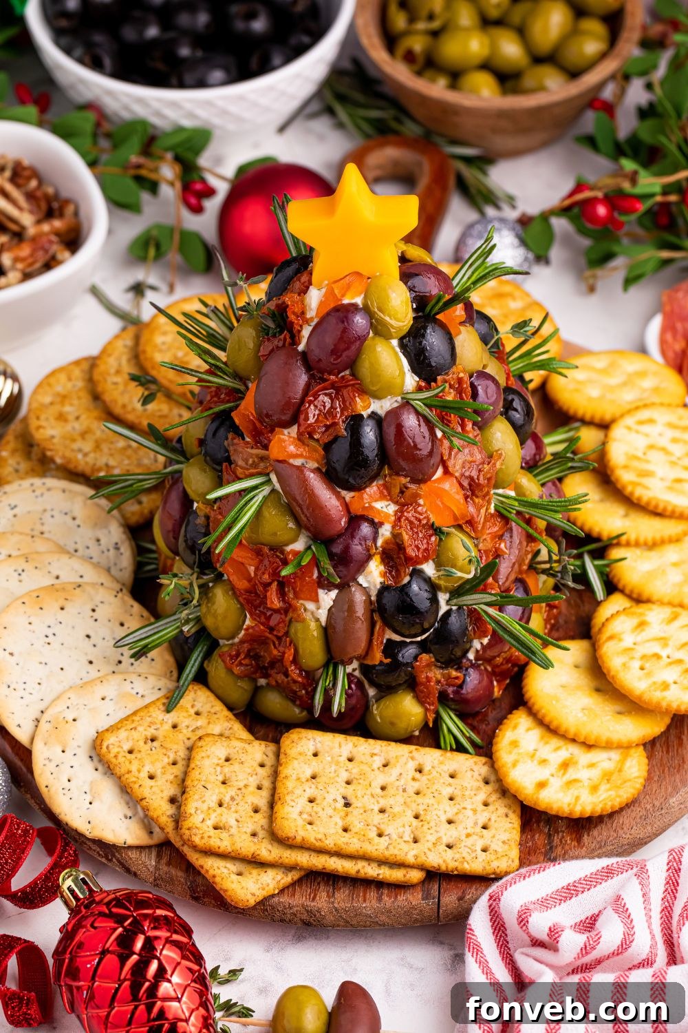Christmas appetizer with crackers around the tray on table, decorated with fresh herbs
