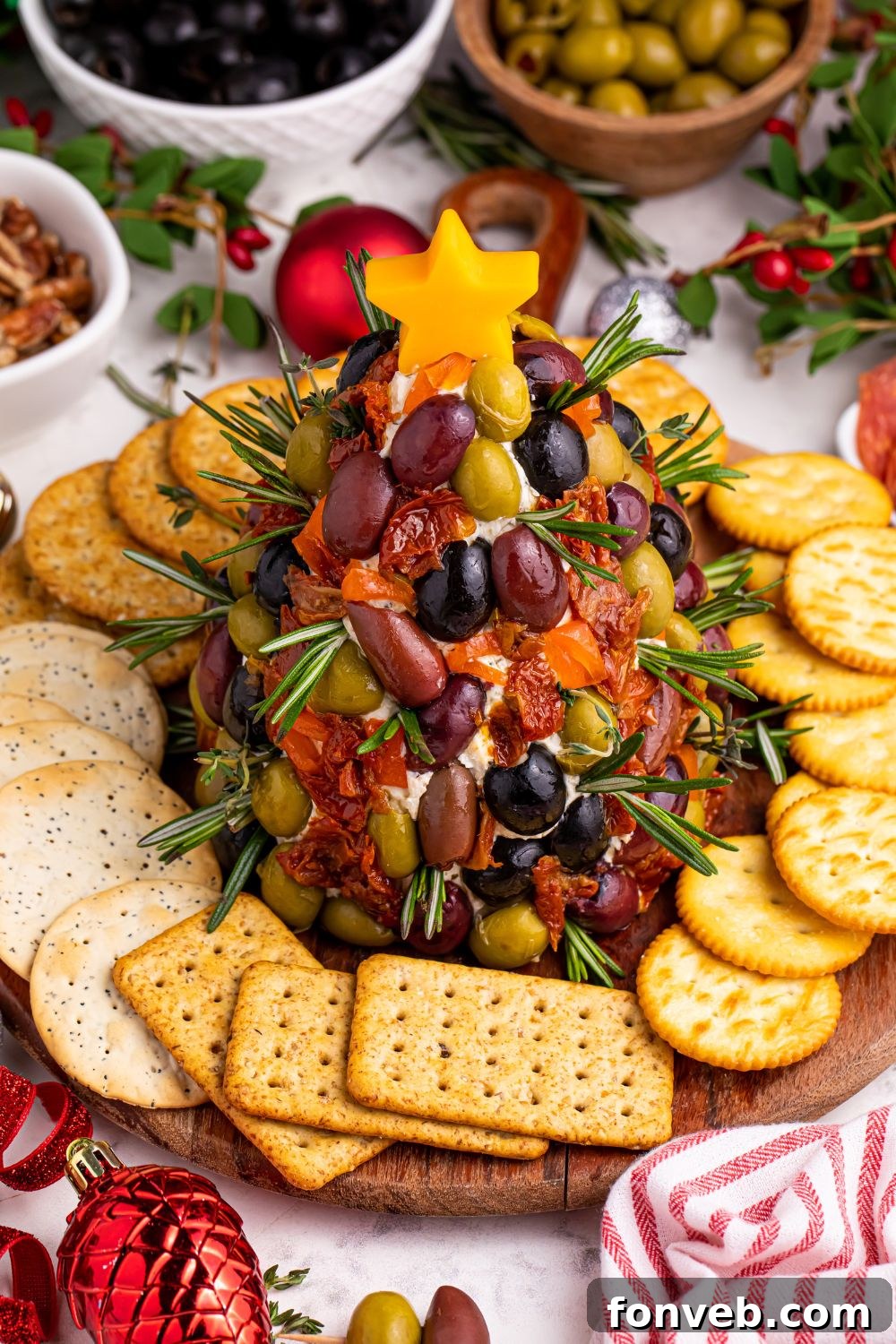 Overhead look of Christmas tree shaped cheeseball on platter, fully decorated