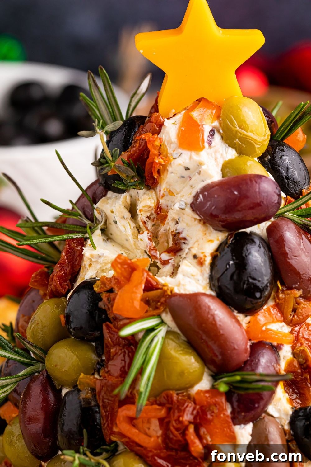 Christmas cheese ball on table with some of it removed, showing texture