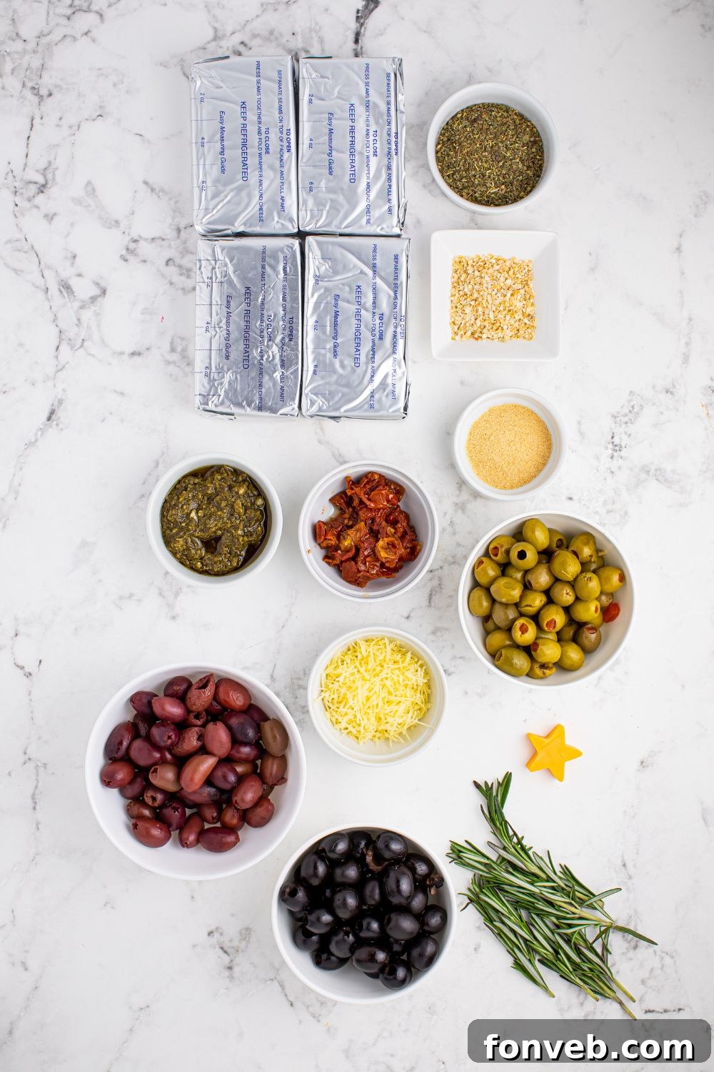 Assorted antipasto cheeseball ingredients laid out on a wooden table