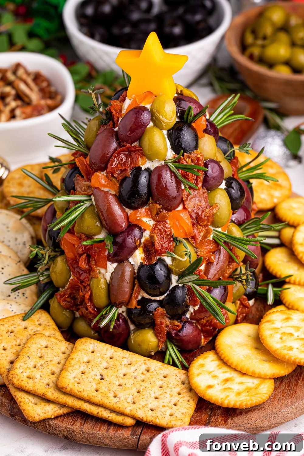 Holiday cheeseball on a platter with crackers and nuts arranged around it for serving