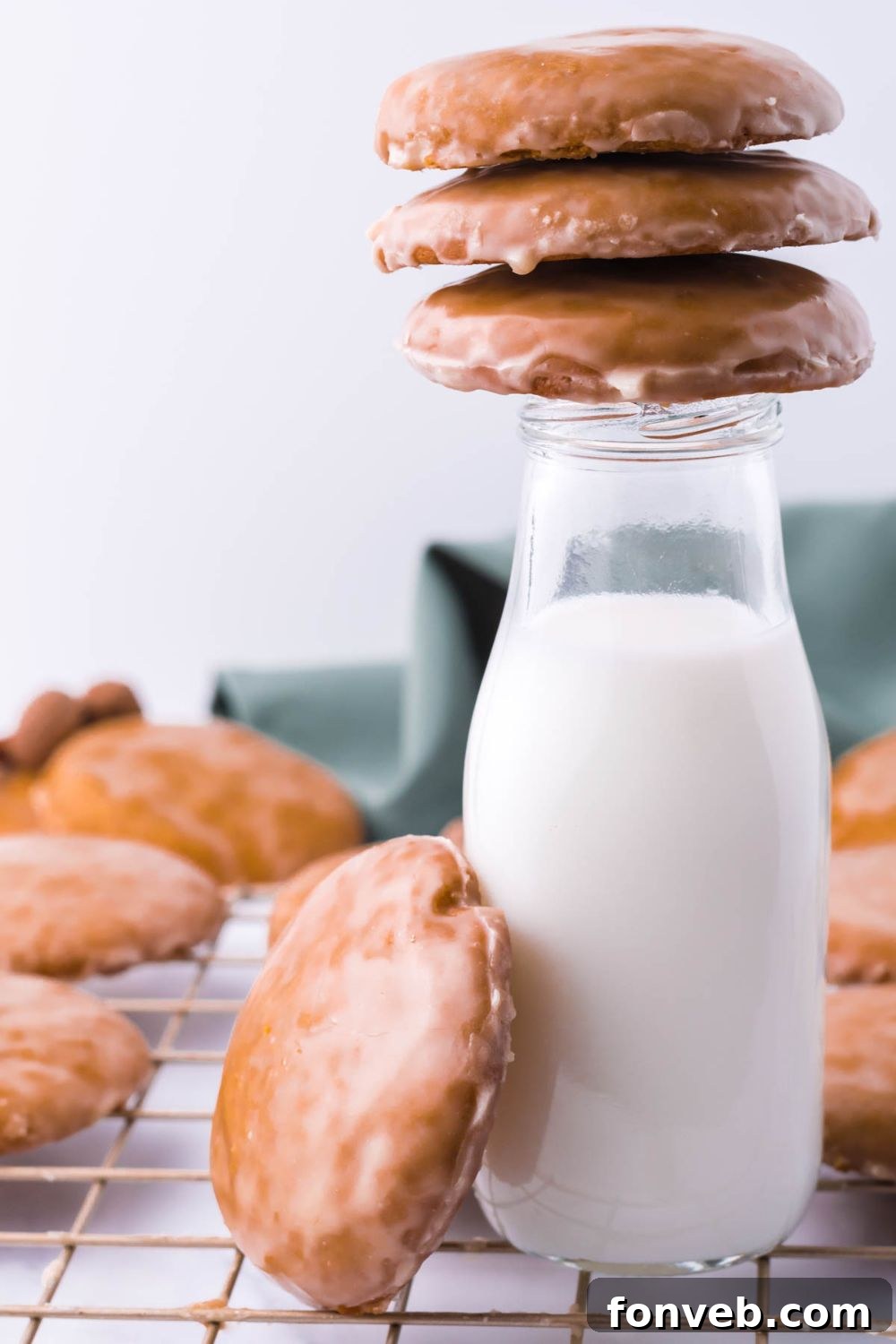 A charming scene featuring a glass milk bottle surrounded by tempting cookies, both on top and beside it.