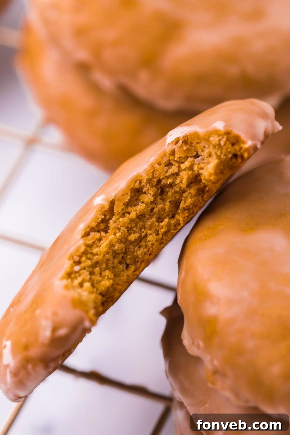 A close-up view of a Lebkuchen cookie with a bite taken out, highlighting its soft texture and inviting glaze.