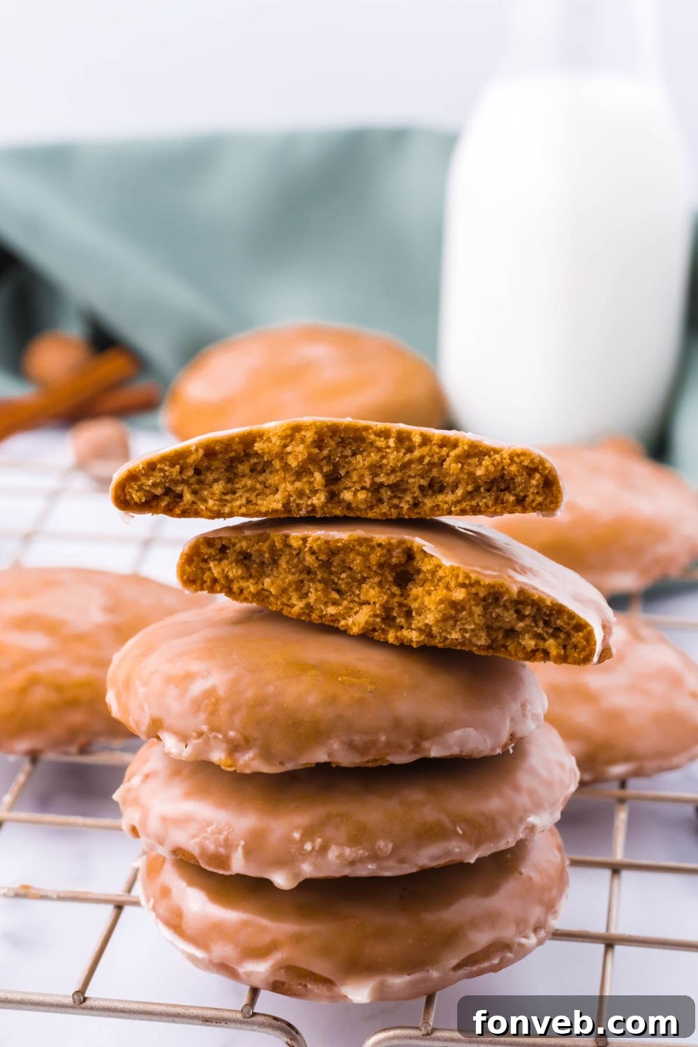 A stack of golden-brown cookies with one broken in half on top, revealing its delightful interior.