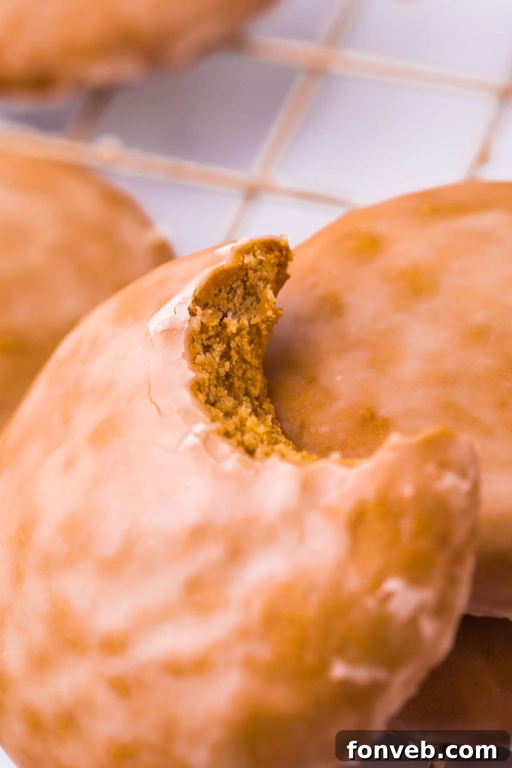 Several glazed Lebkuchen gingerbread cookies cooling on a wire rack, with one cookie showing a bite taken out.