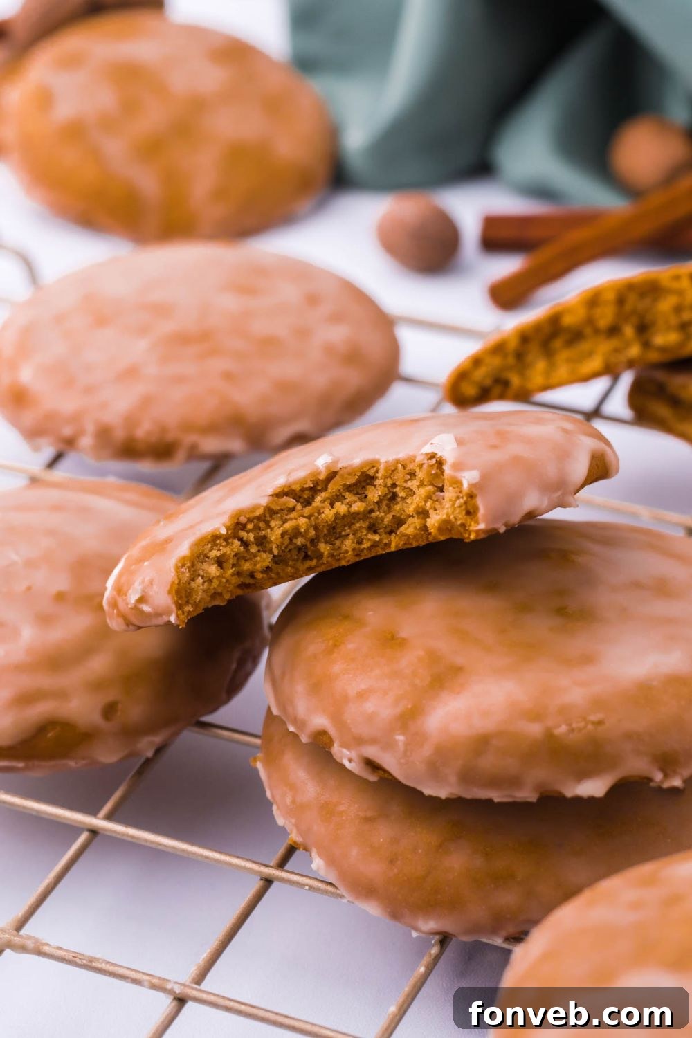 A single German cookie with a bite taken out, gently placed atop a pile of other cookies.