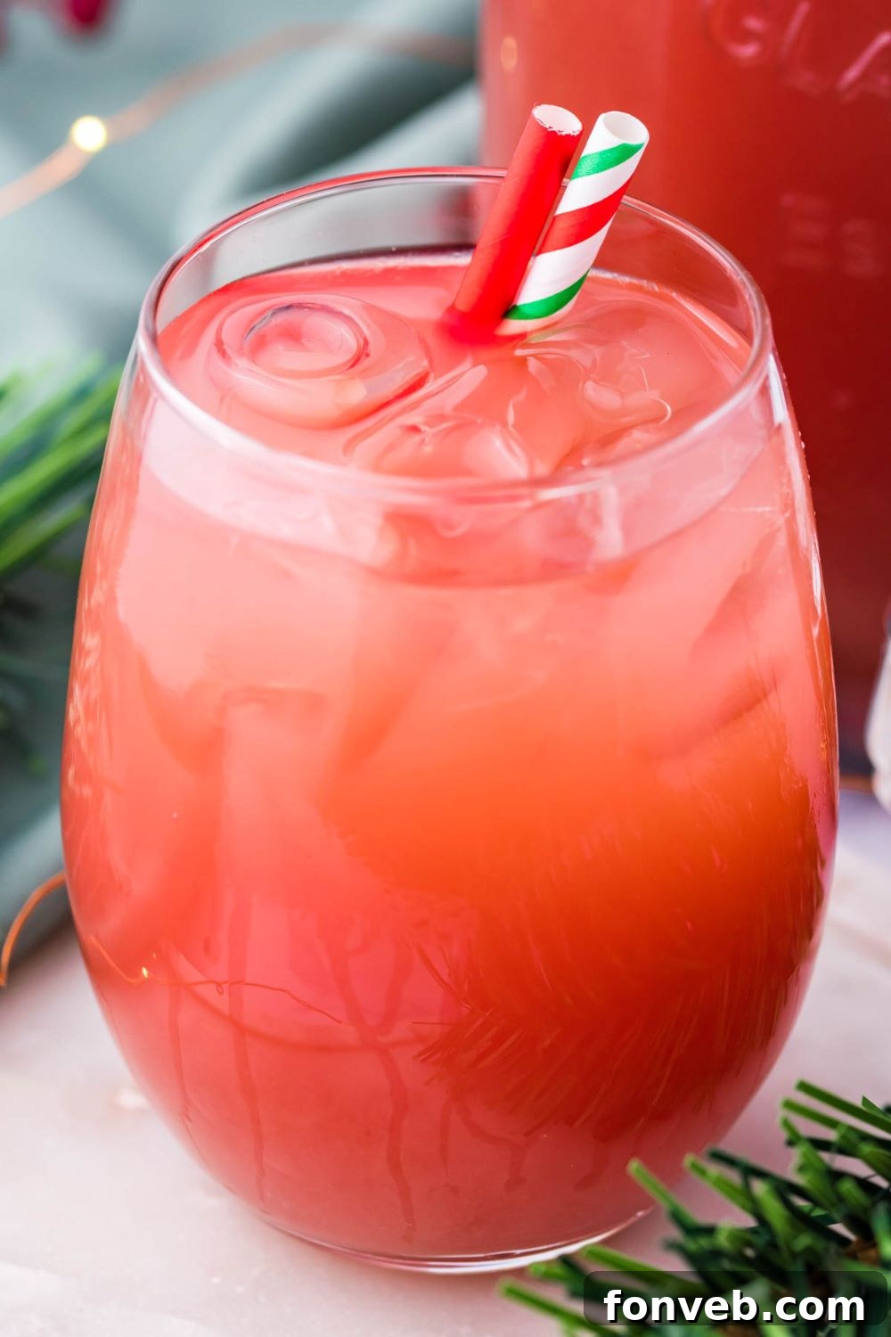 Mistletoe Mix 4 holiday cranberry punch in a glass with two straws