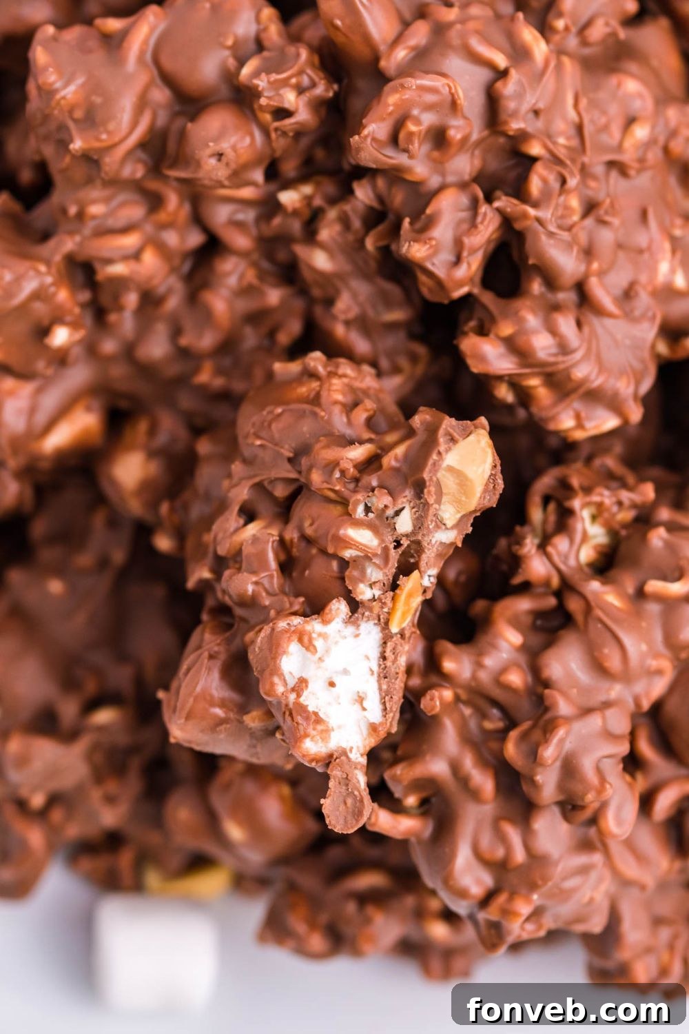 Various pieces of Rocky Road Candy scattered on a wooden table, emphasizing their rustic appeal.