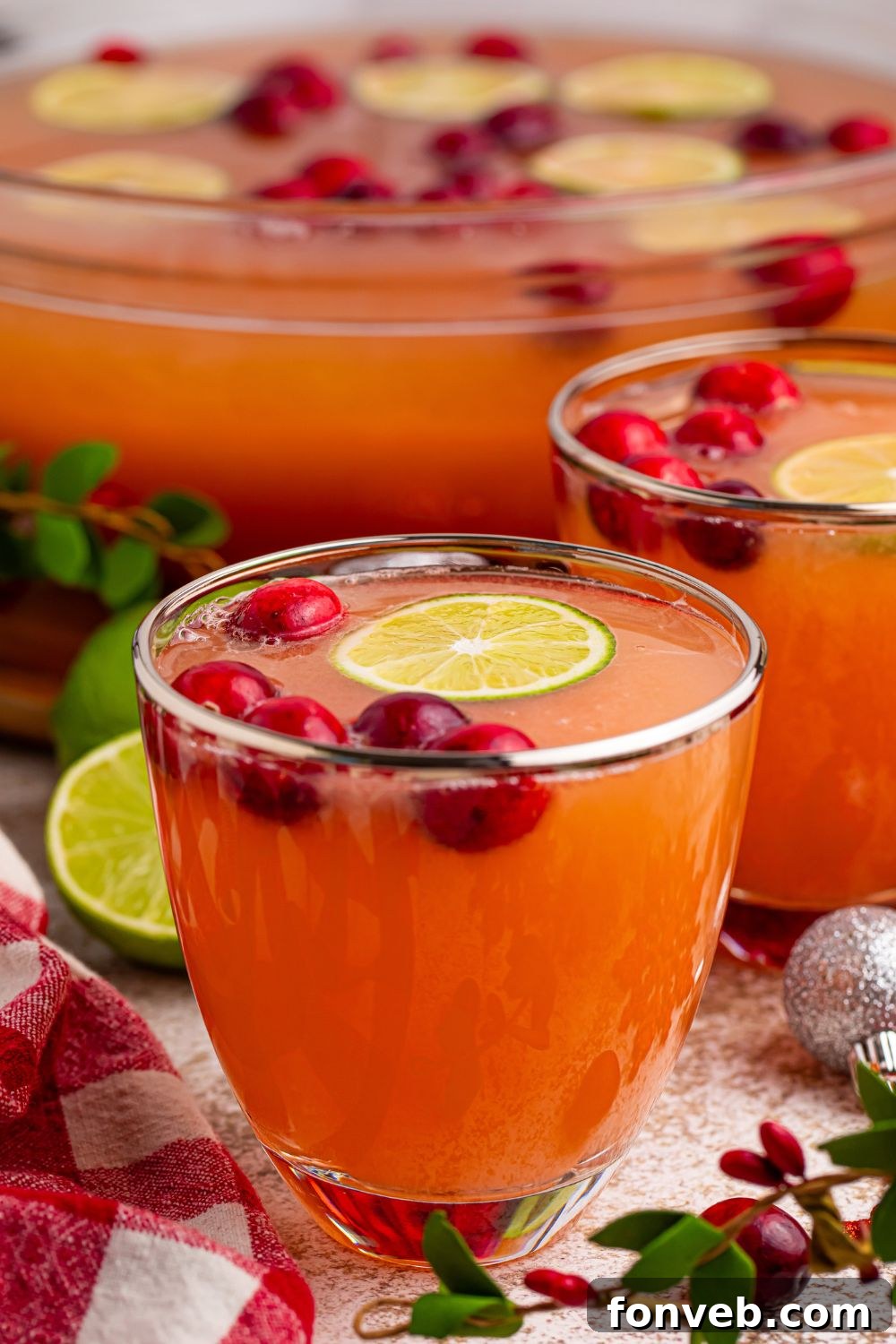 Two glasses of vibrant Giggle Juice Punch on a wooden table, ready for guests.
