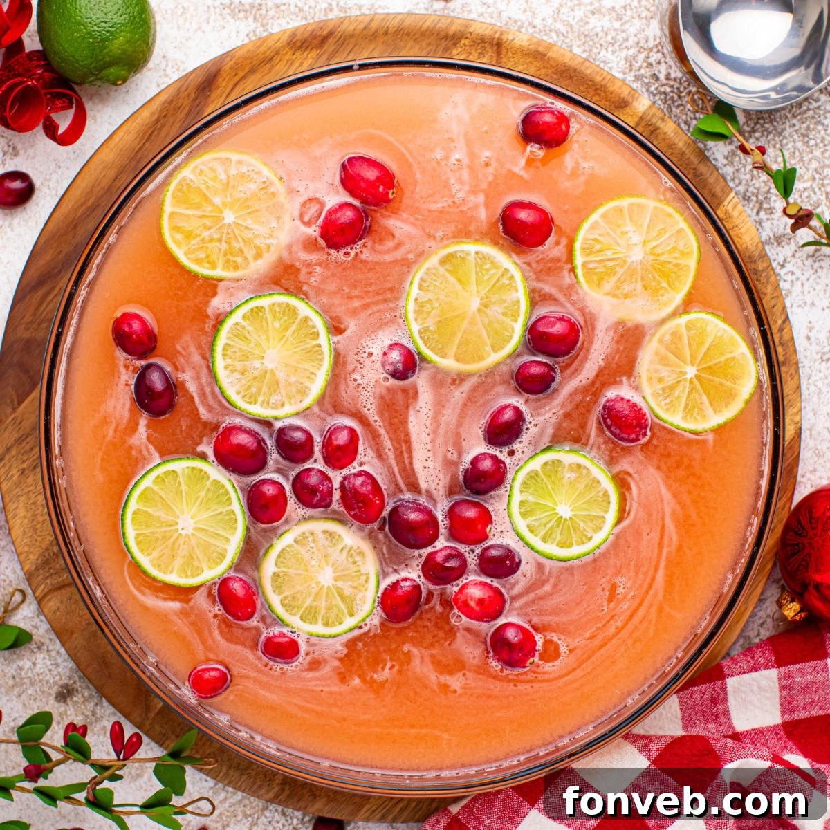 Santa's Giggle Juice Punch shimmering in a large punch bowl, set on a rustic wooden table, ready for a festive gathering.