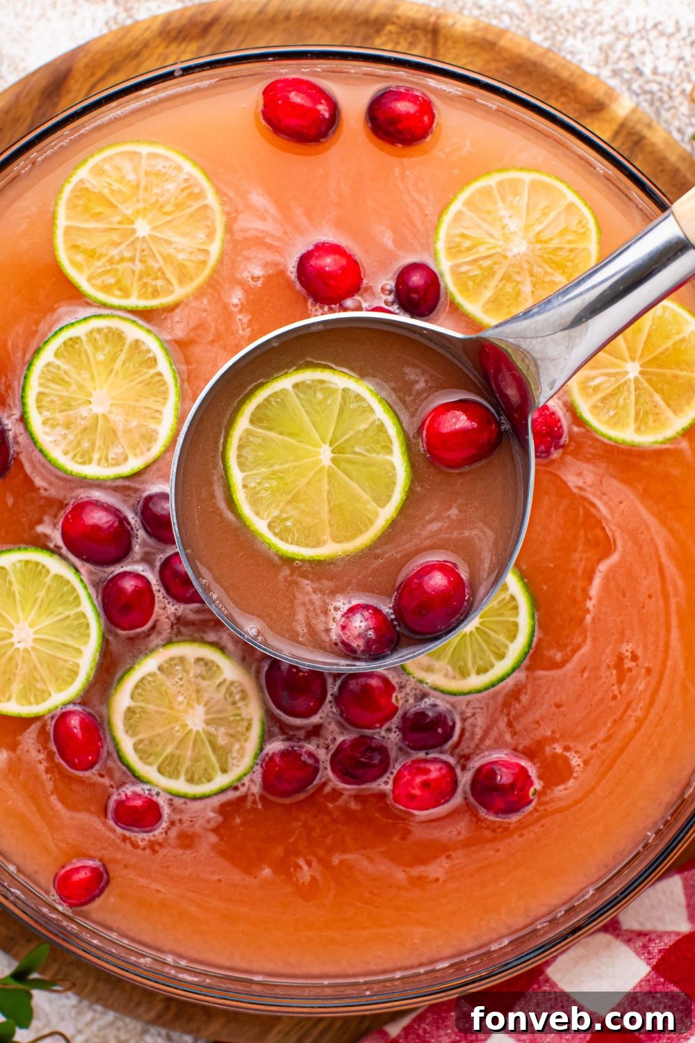 Close-up of a festive Christmas punch in a large glass bowl, showcasing the frothy sherbet and vibrant colors.