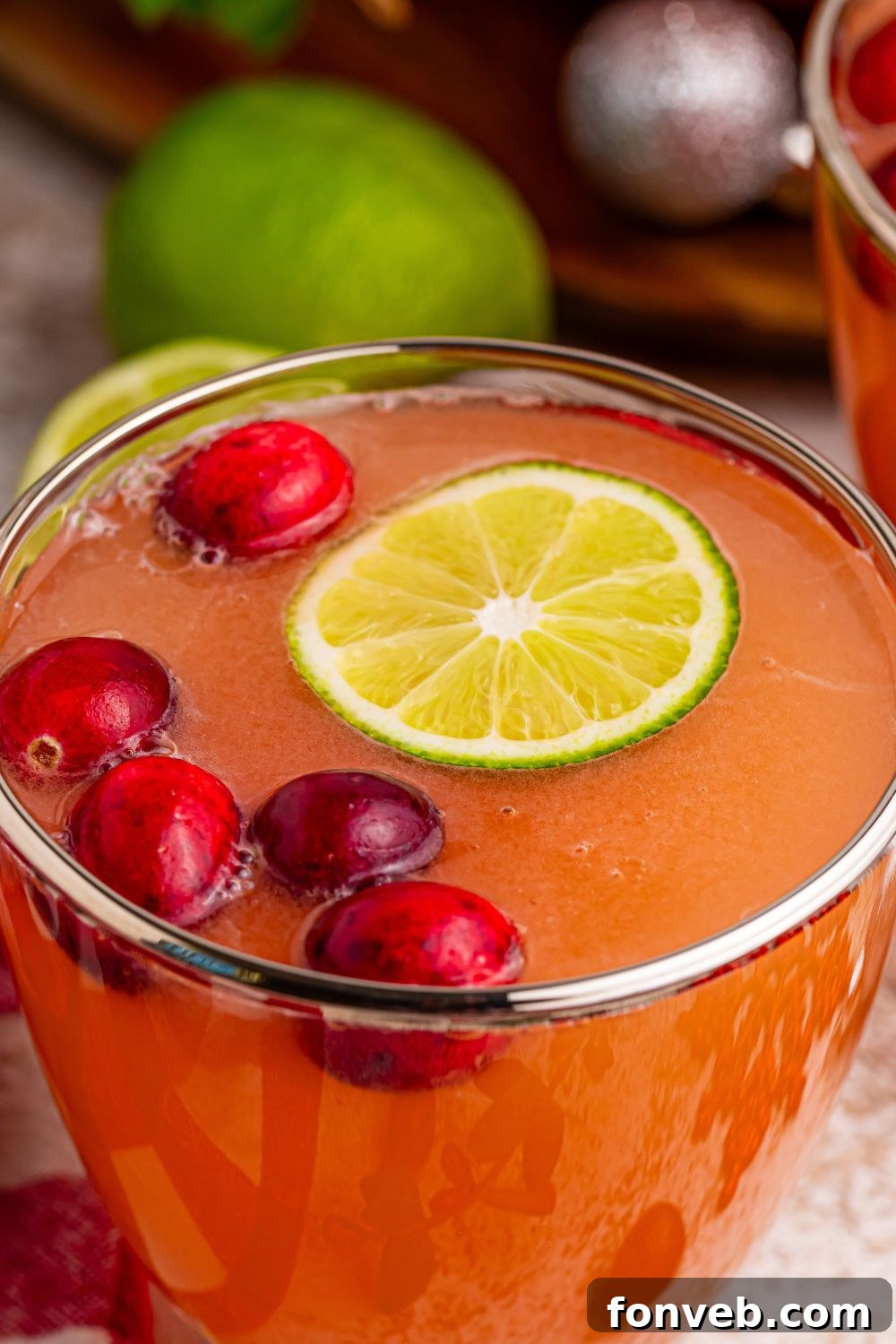 A single glass of cranberry punch with a frothy top, ready to be enjoyed as a holiday cocktail.